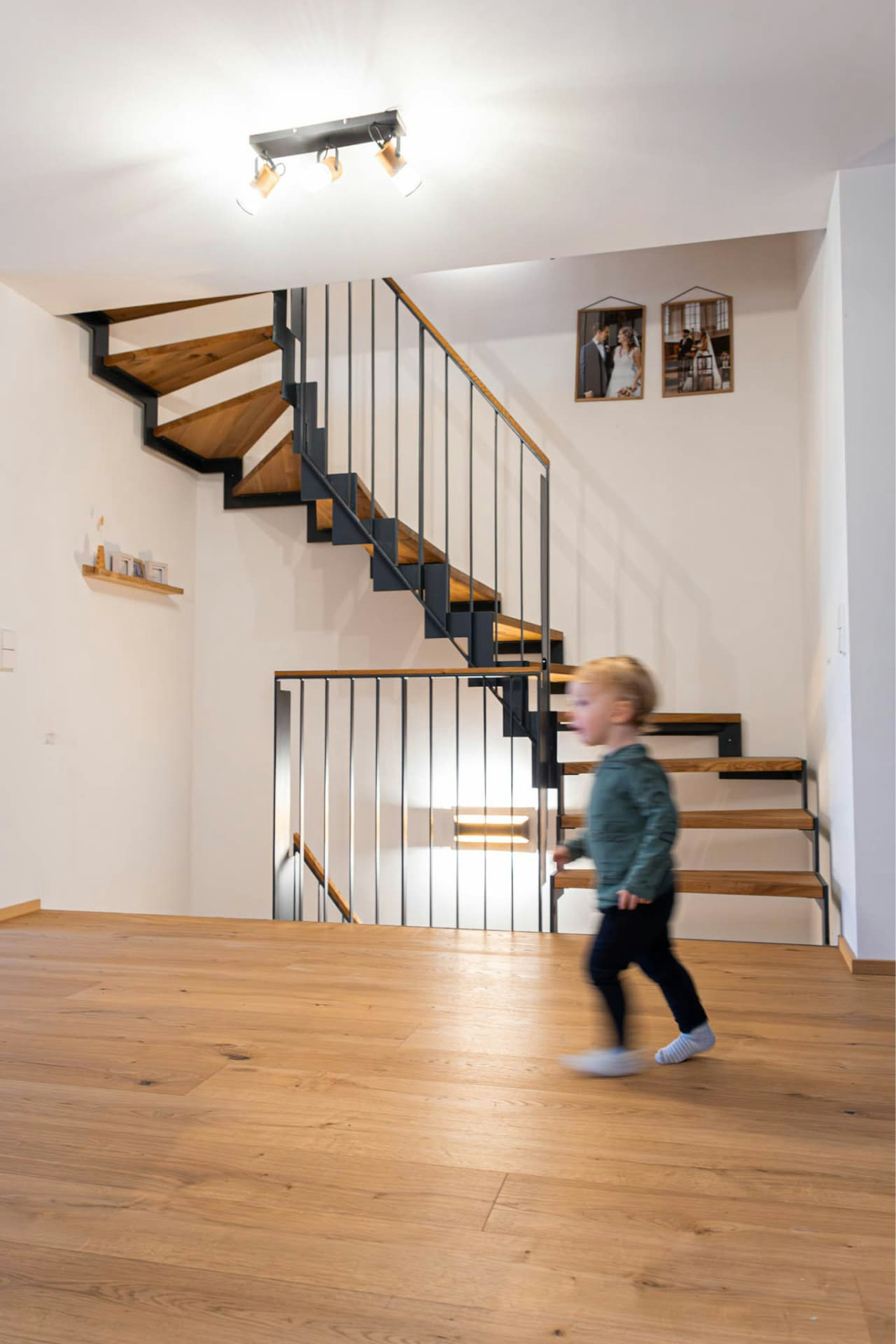 Parkett und Treppe von Parkett Saussele in einem modernen Haus, kleines Kind auf dem Boden spielend 