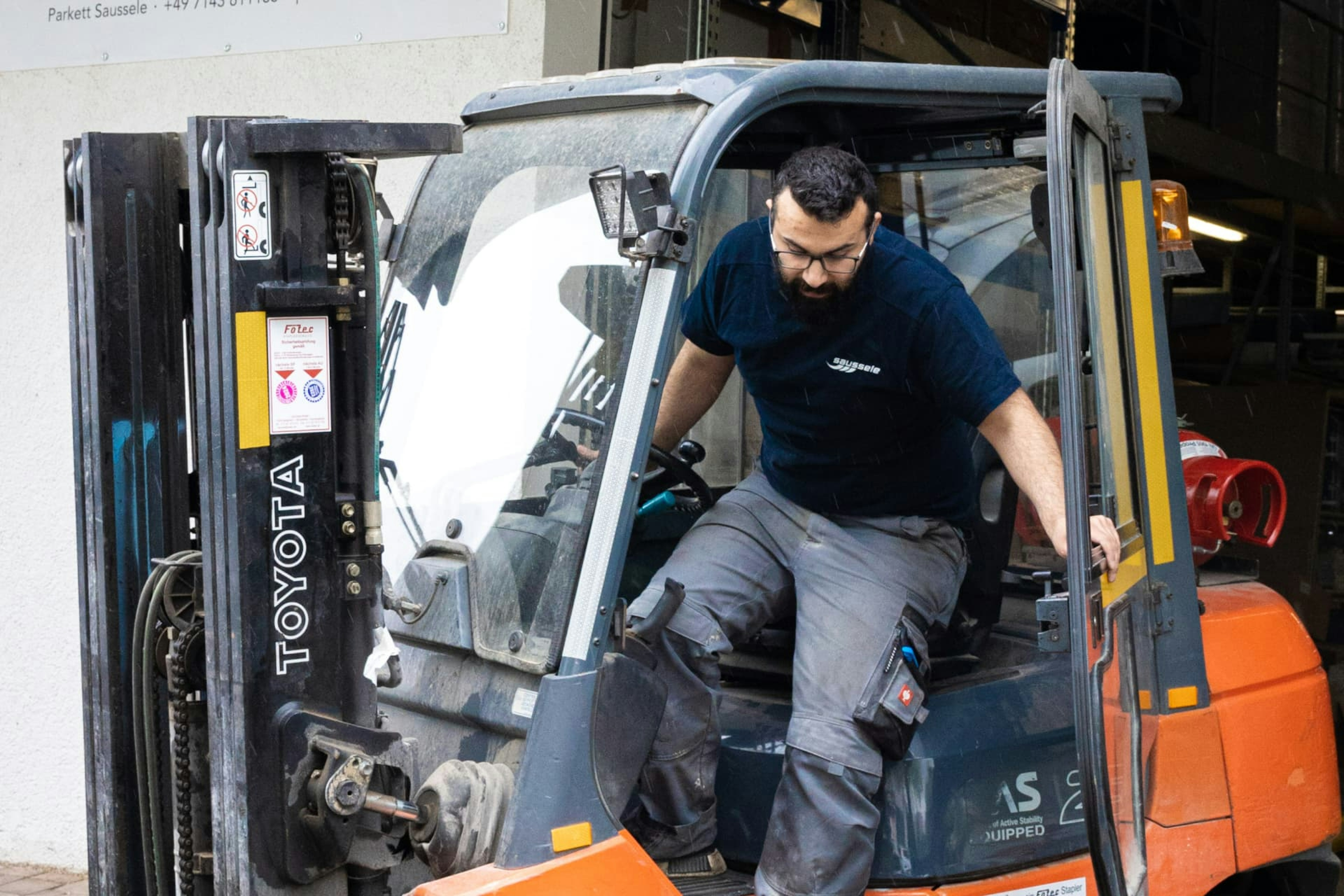 Mitarbeiter von Parkett Saussele Akin Sevilmis bei der Arbeit in der Lagerhalle