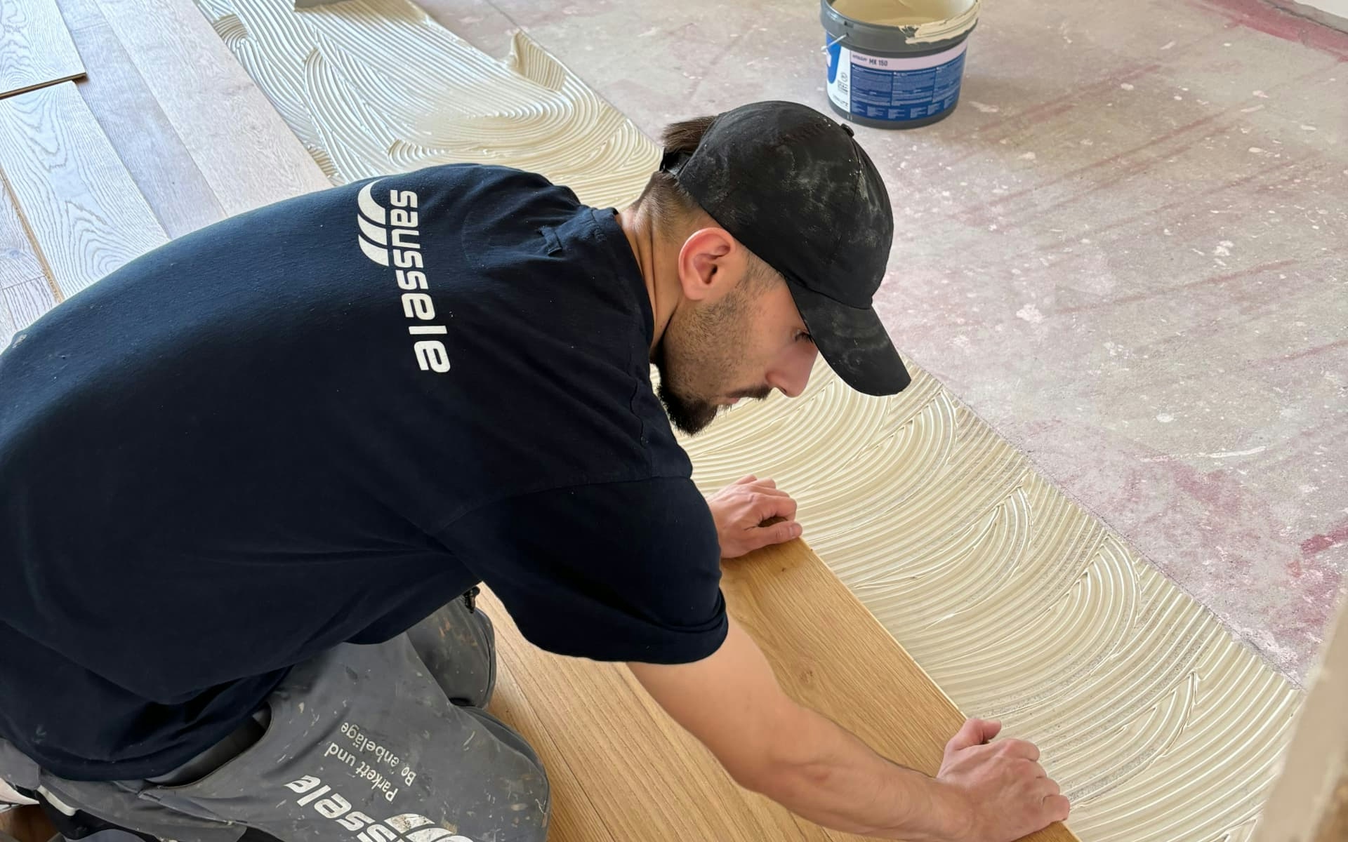 Mitarbeiter von Parkett Saussele bei der Verlegung eines Parkettbodens