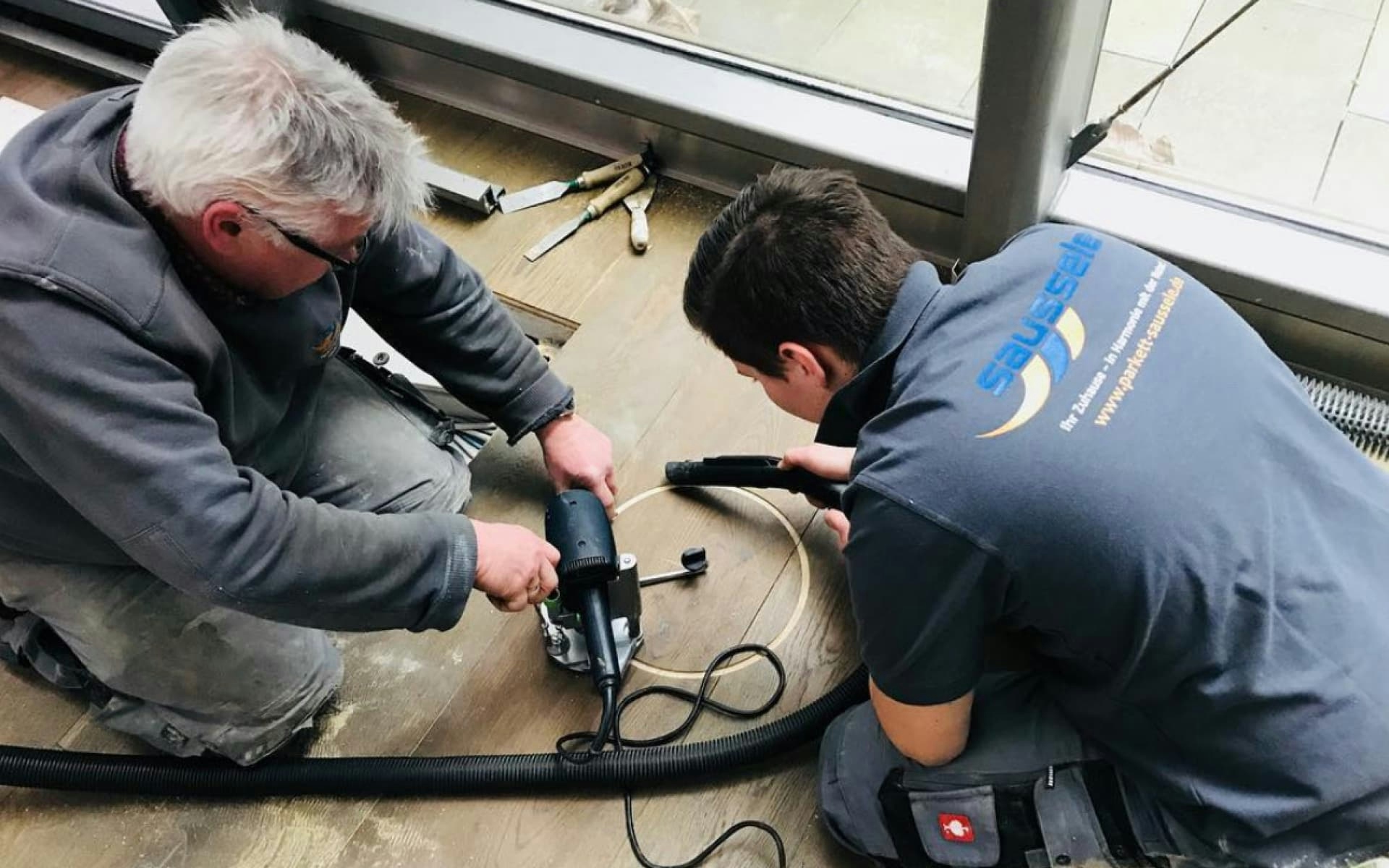Mitarbeitende von Parkett Saussele bei der Arbeit, Verlegung eines Parkettbodens