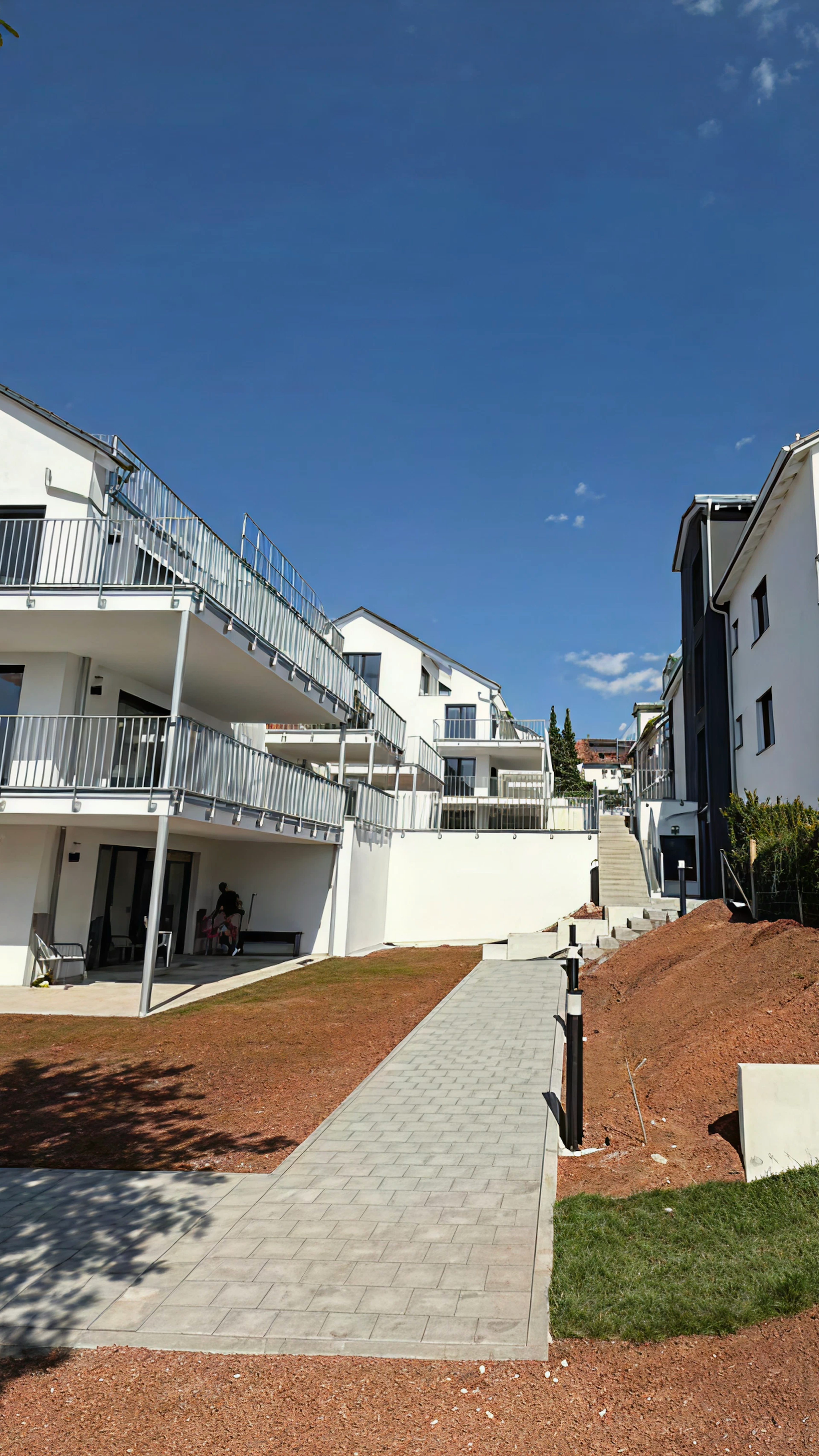 Wohnanlage mit breitem Gehweg, Treppe und neu angelegtem Außenbereich