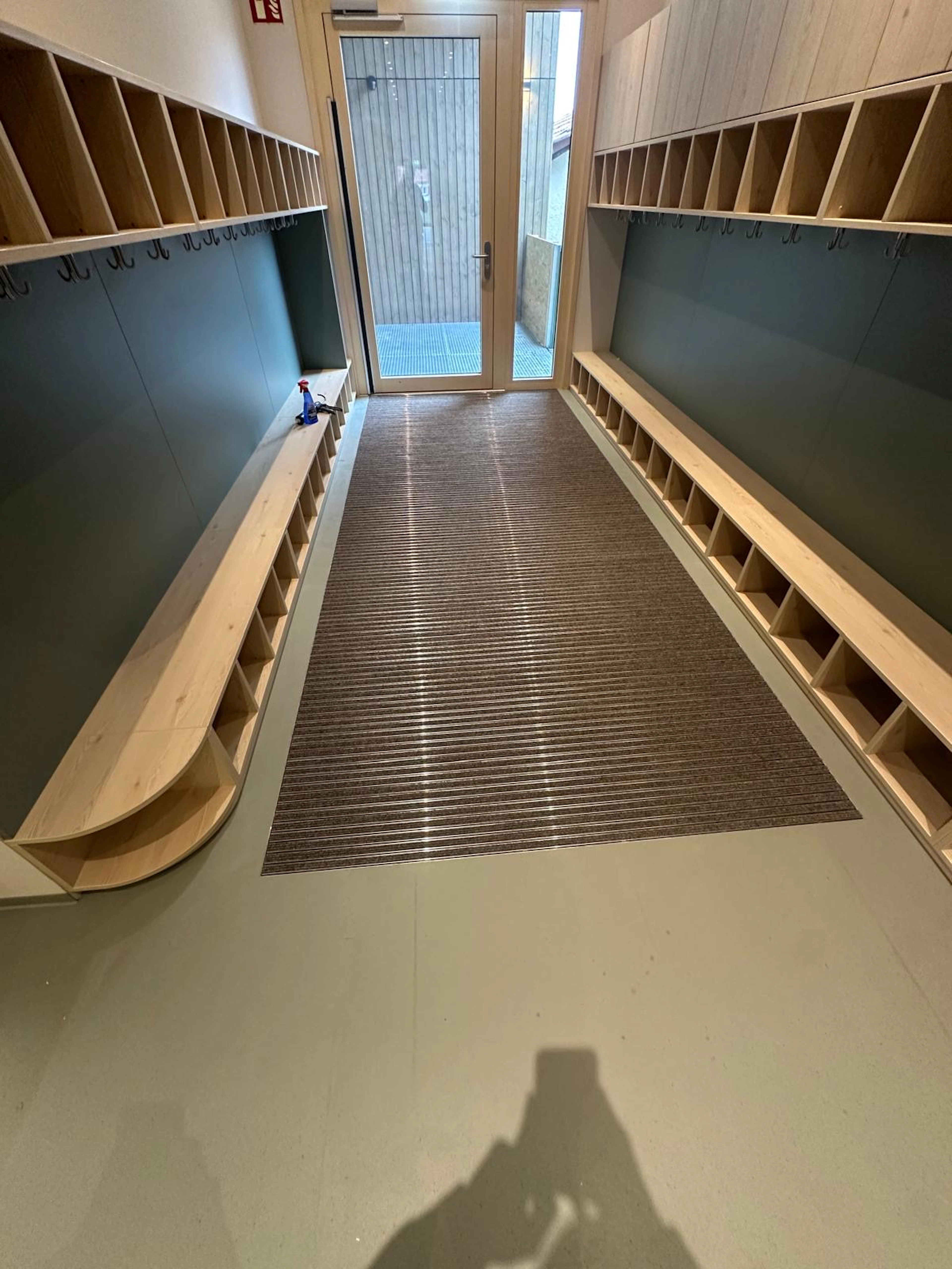Sauberlaufmatte auf grauem Industrieboden in einer modernen Garderobe