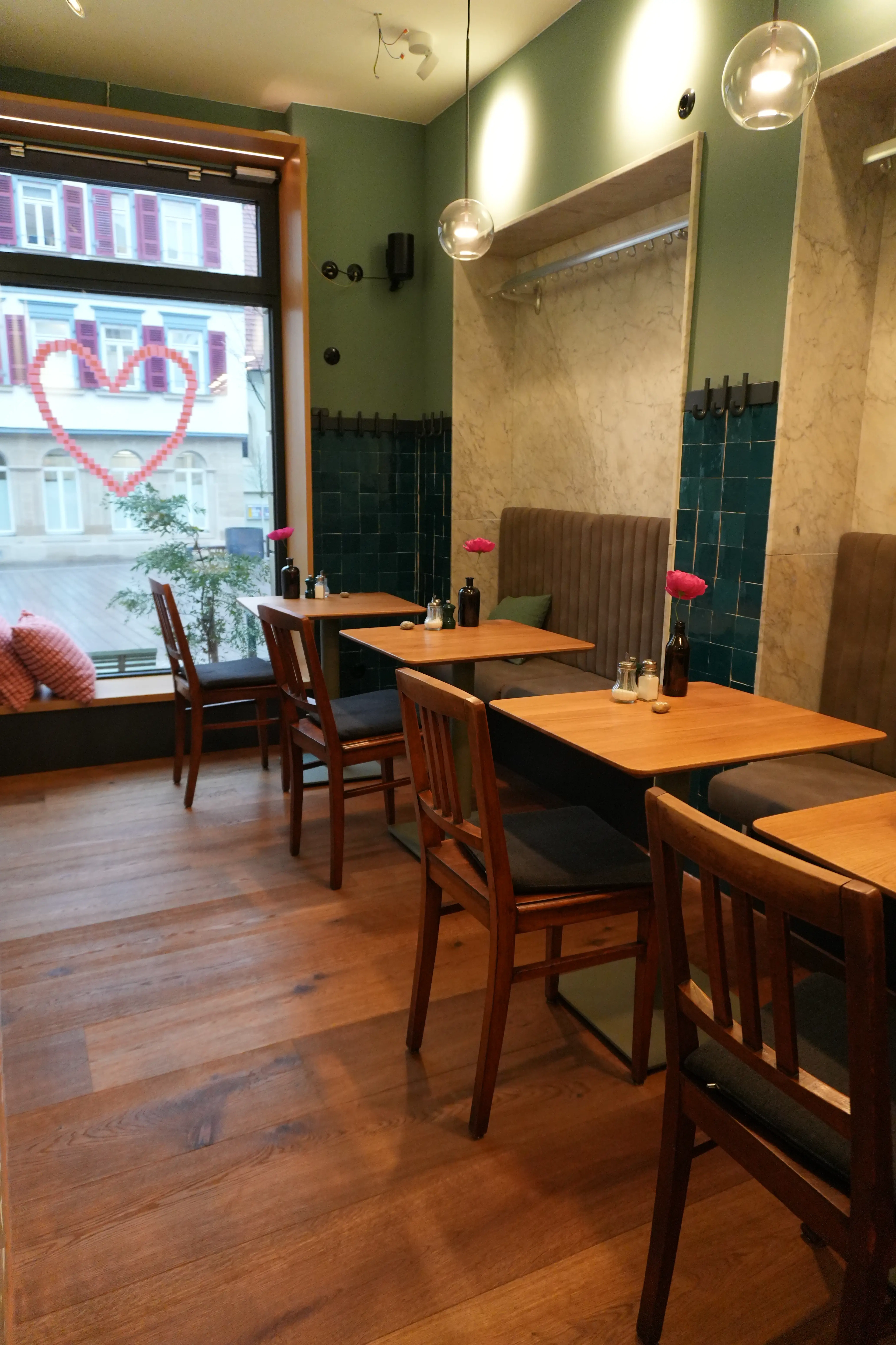 Massivholzparkett in modernem Restaurant mit Holztischen und grünen Wandfliesen