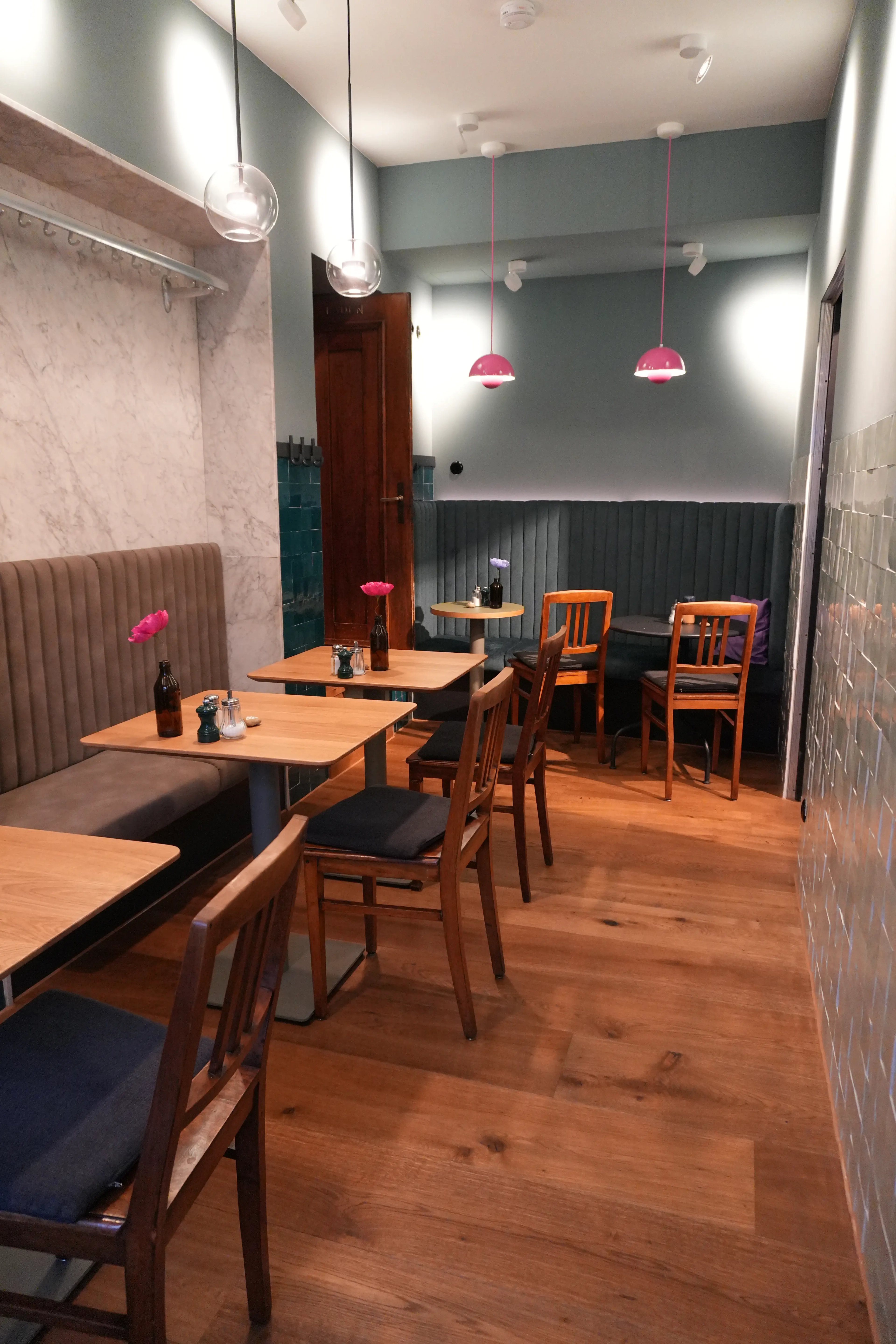 Großzügiger Gastraum mit durchgehend verlegtem Parkettboden und Sitznischen