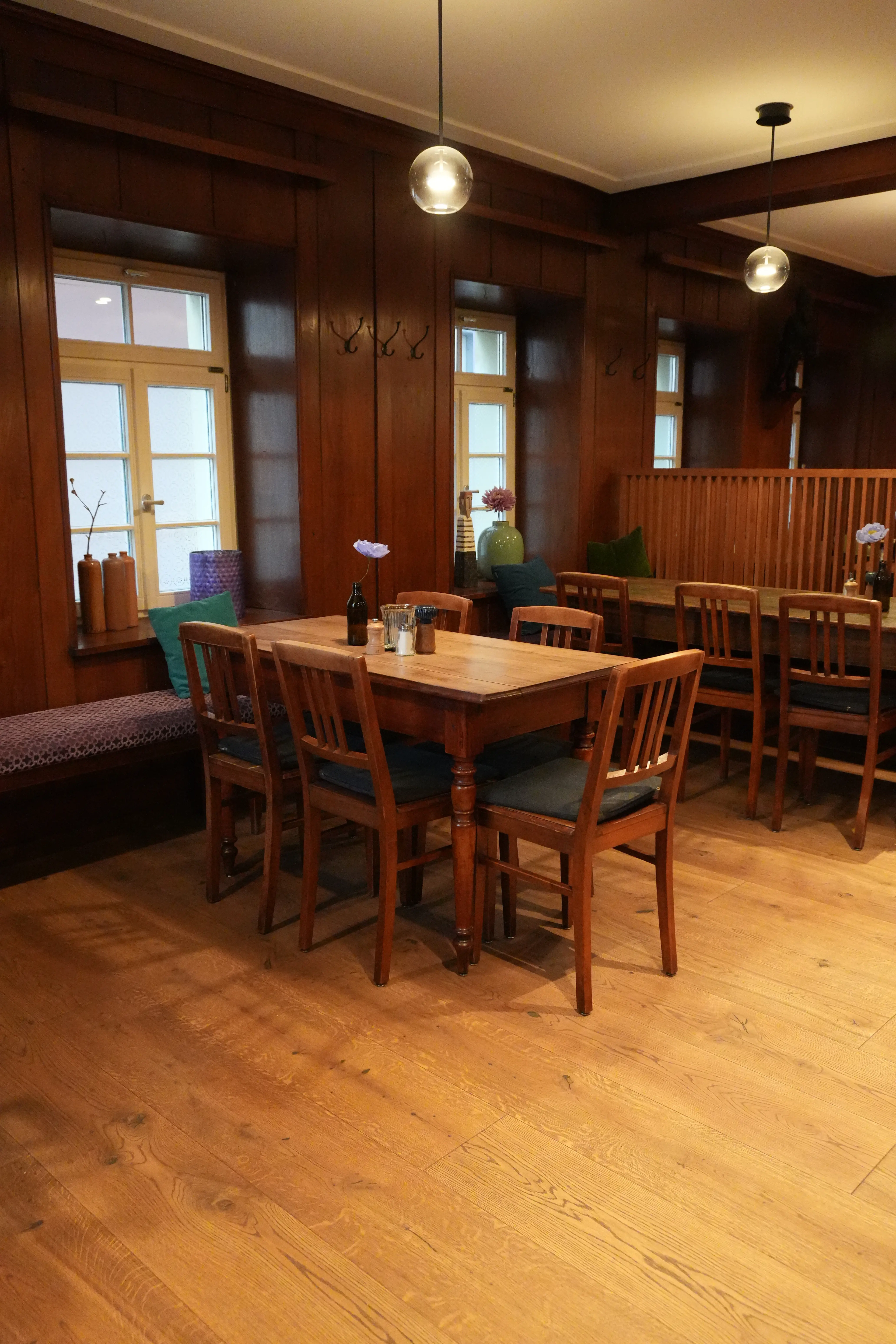 Massiver Esstisch auf geöltem Parkettboden in einer traditionellen Weinstube