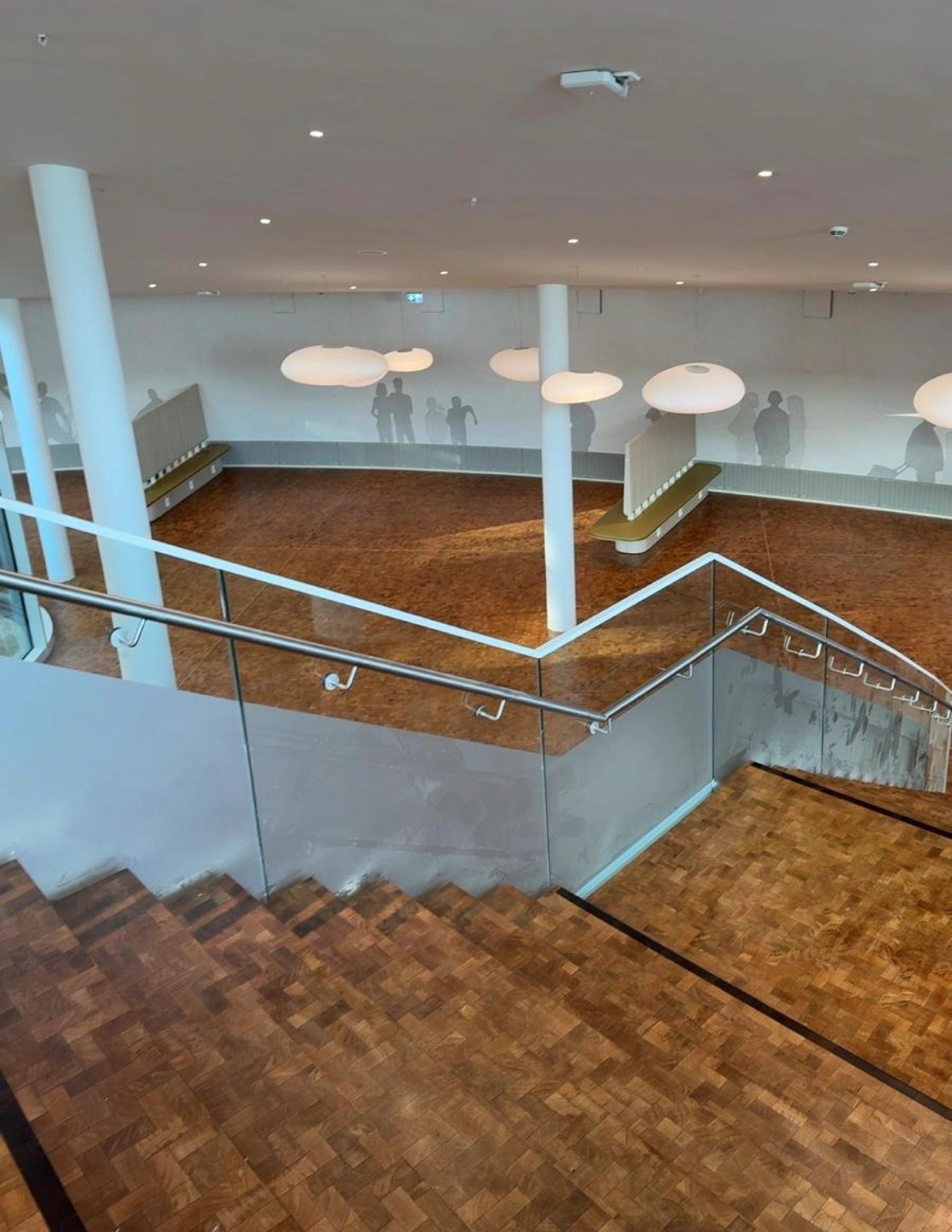 Blick von oben auf eine Parketttreppe und die weitläufige, sanierte Bodenfläche