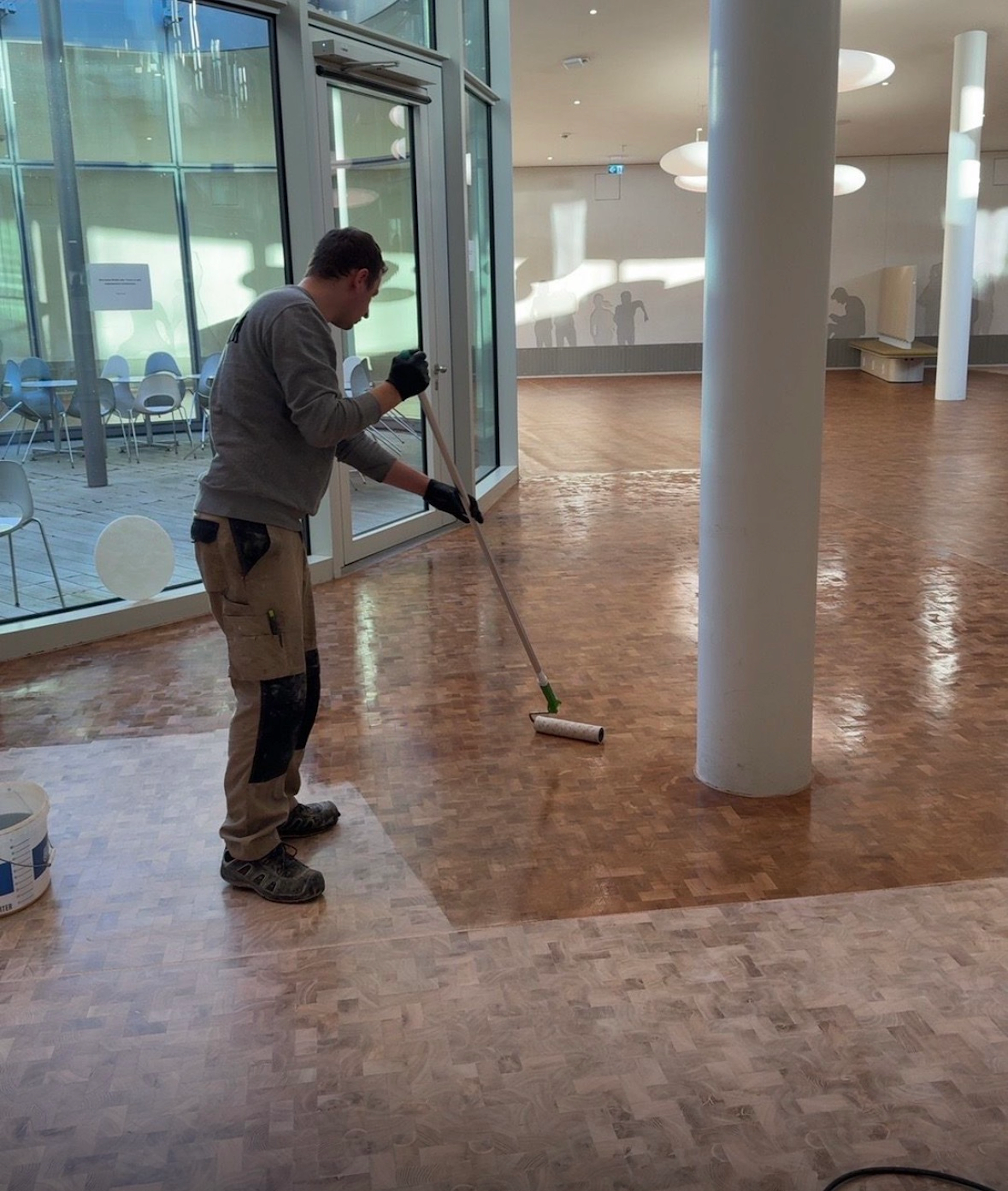 Auftragen von Parkettöl auf Mosaikparkett zur Auffrischung der Holzoberfläche