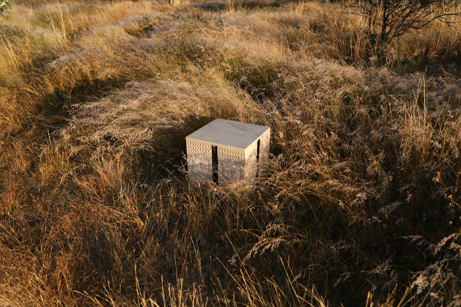 LANDIN Stone Side Table sits in the warm mexican sun in a field of grass