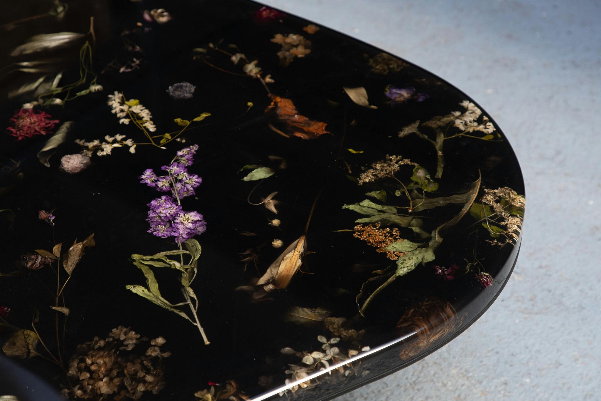Details of flowers suspended in inky black resin in Marcin Rusak's FLORA coffee table