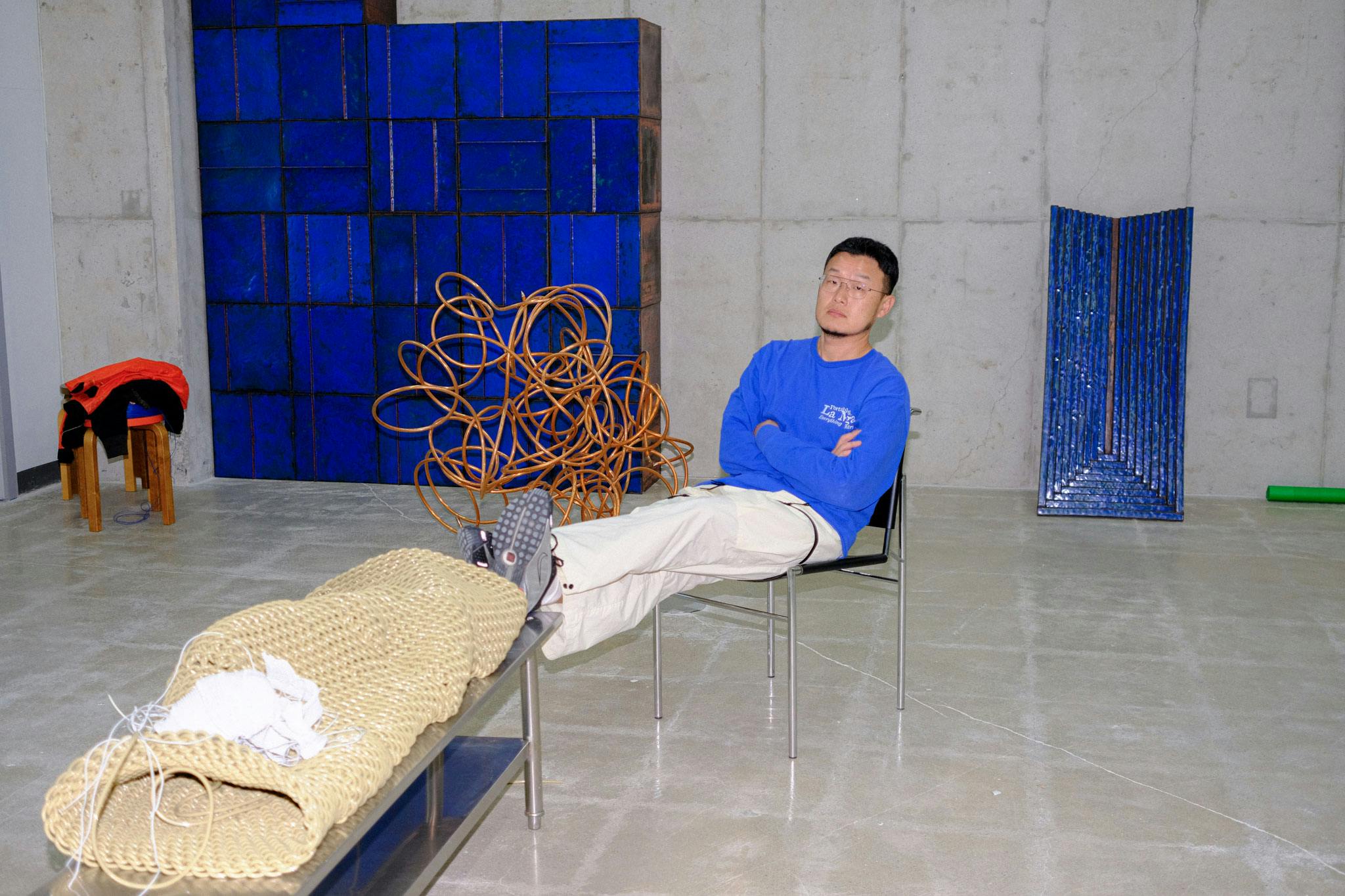 Kwangho Lee sits surrounded by pieces of his in Chilbo Enamel, Coppen and woven PVC in his Seoul Studio | Photo by Kristen de la Vallière
