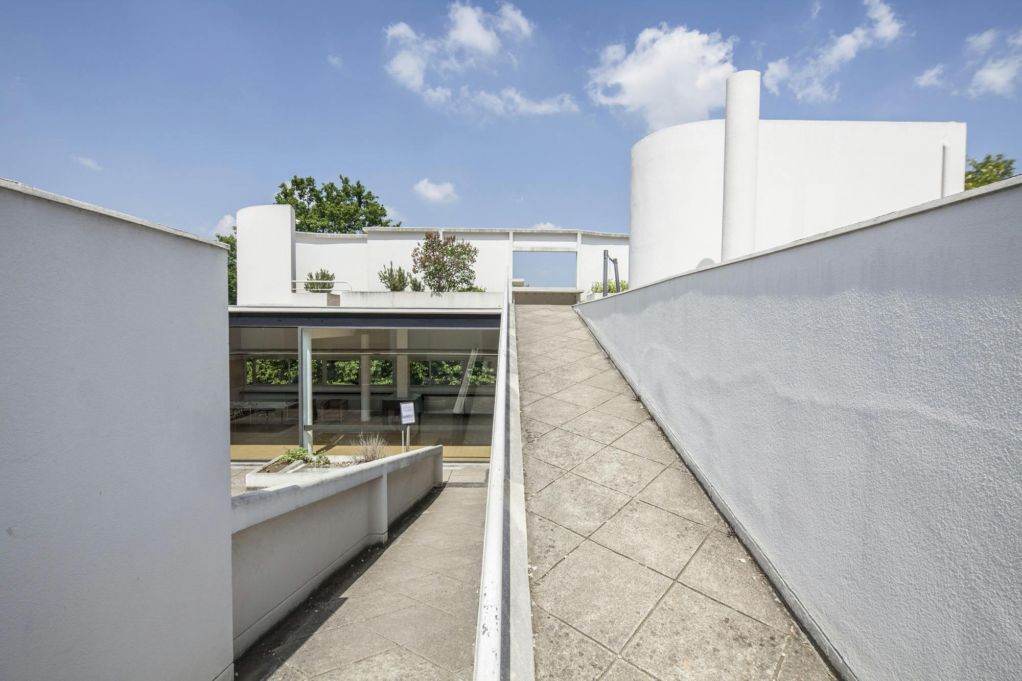 With Le Corbusier, the roof is no longer just protection, but a new living space. This hanging garden includes a solarium, open to the sky but protected from the prevailing winds by a curved wall like a concrete screen.  The landscape, with its view of the meandering Seine, is also featured. A rectangular opening in the wall, also known as a "hole in the wall", acts as a frame to direct the viewer's gaze.