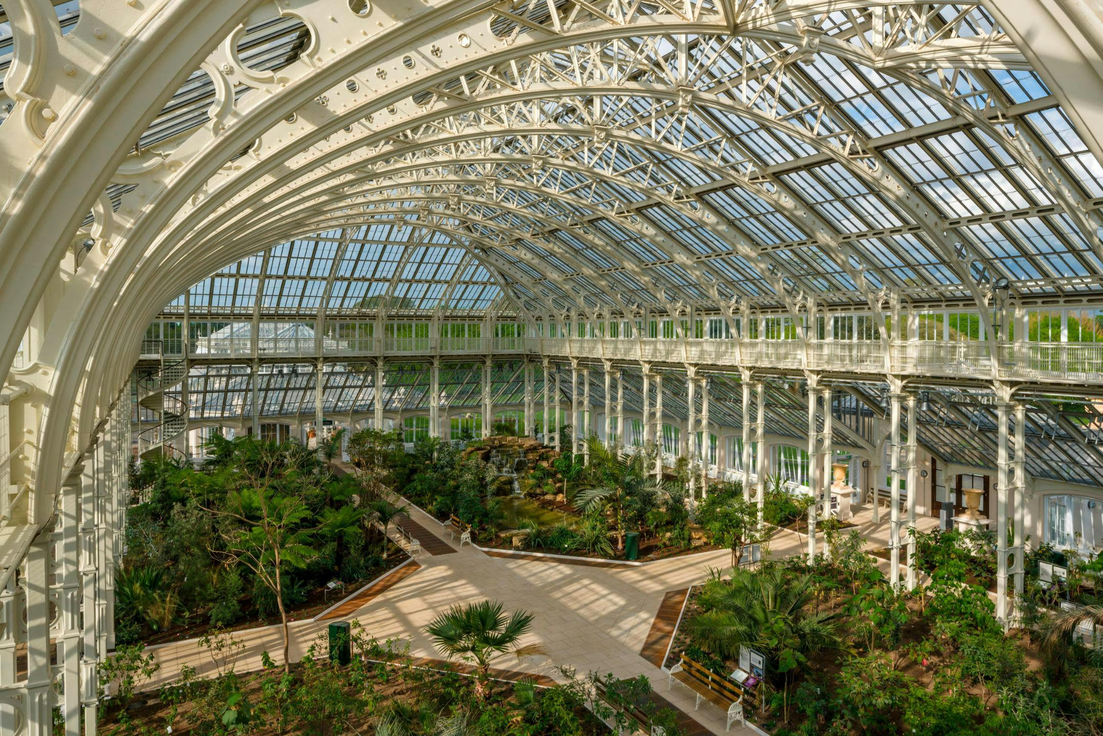 The glasshouses at Kew Gardens, including the iconic Palm House, Temperate House, and Princess of Wales Conservatory, are architectural marvels that use glass and iron to create controlled environments for diverse plant species from around the world, blending historical design with modern technology for plant preservation and display.