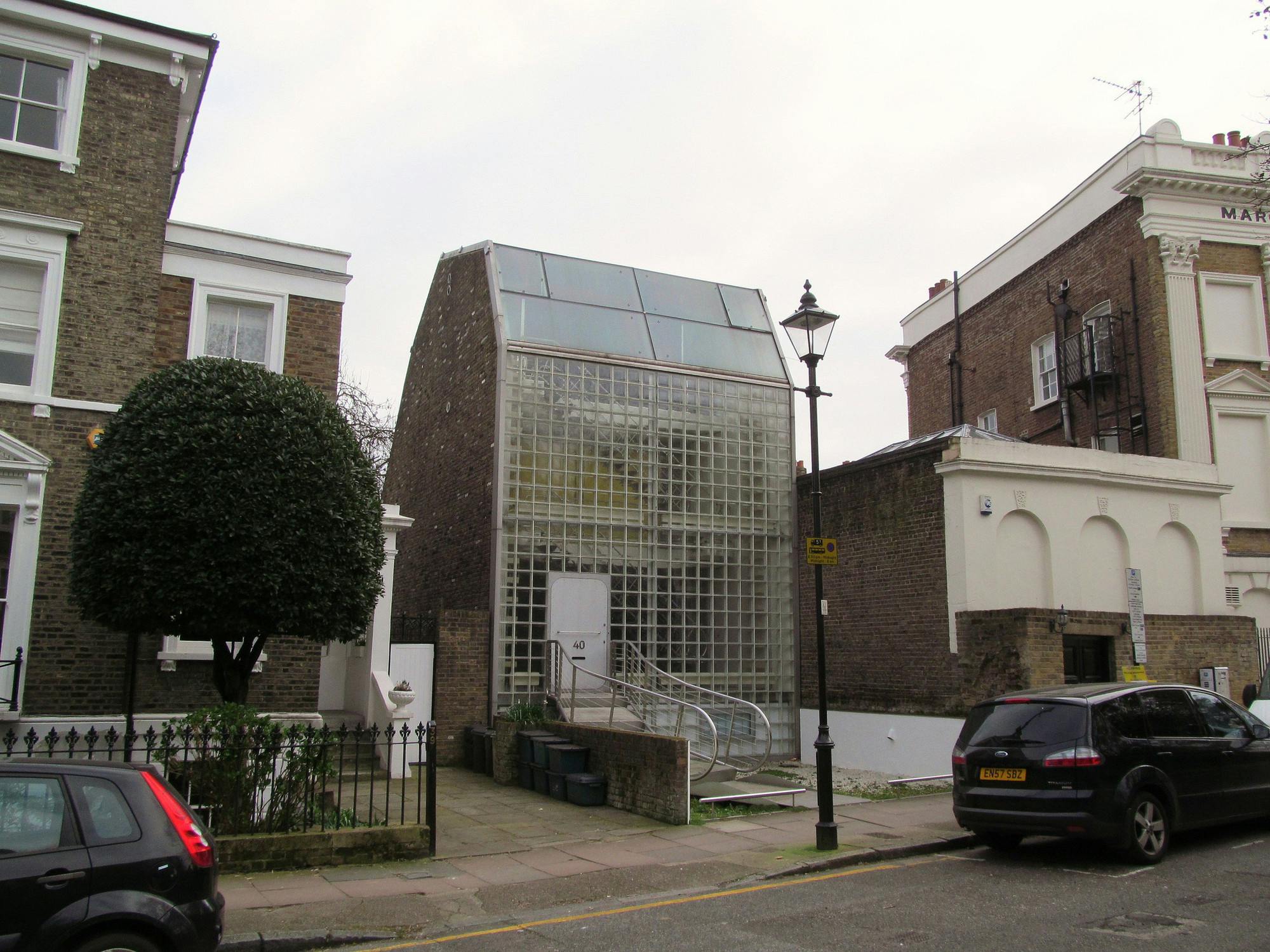 The exterior of the house is defined by a clean, geometric façade, predominantly constructed from concrete and brick. One notable detail is the use of large, asymmetrically placed windows, which not only bring in an abundance of natural light but also create a dynamic interplay of light and shadow throughout the day.