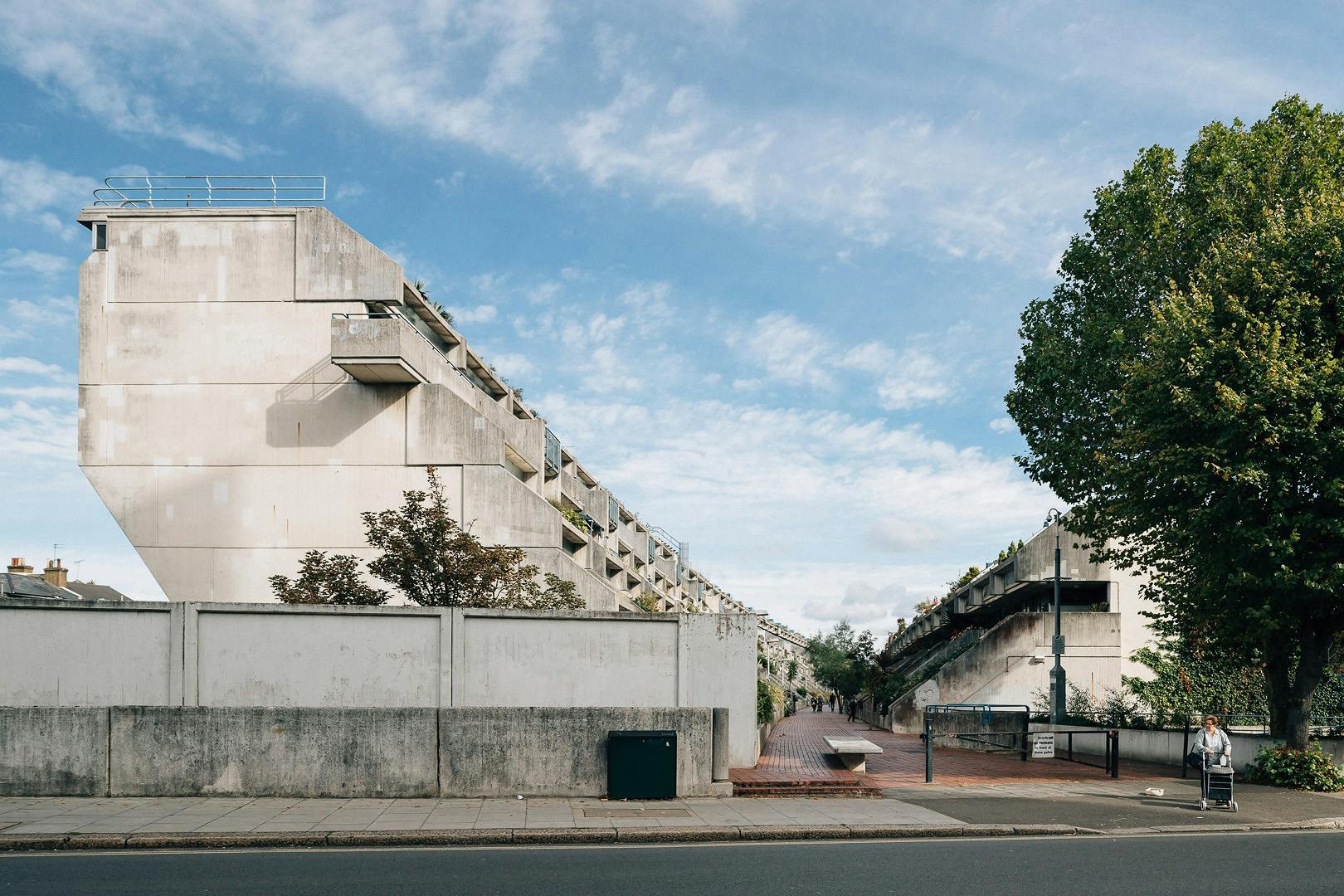 The estate is composed of three long, curved blocks that form a distinctive stepped design, with terraces cascading downward. This design provides each apartment with large private outdoor spaces, almost like modern-day gardens in the sky.