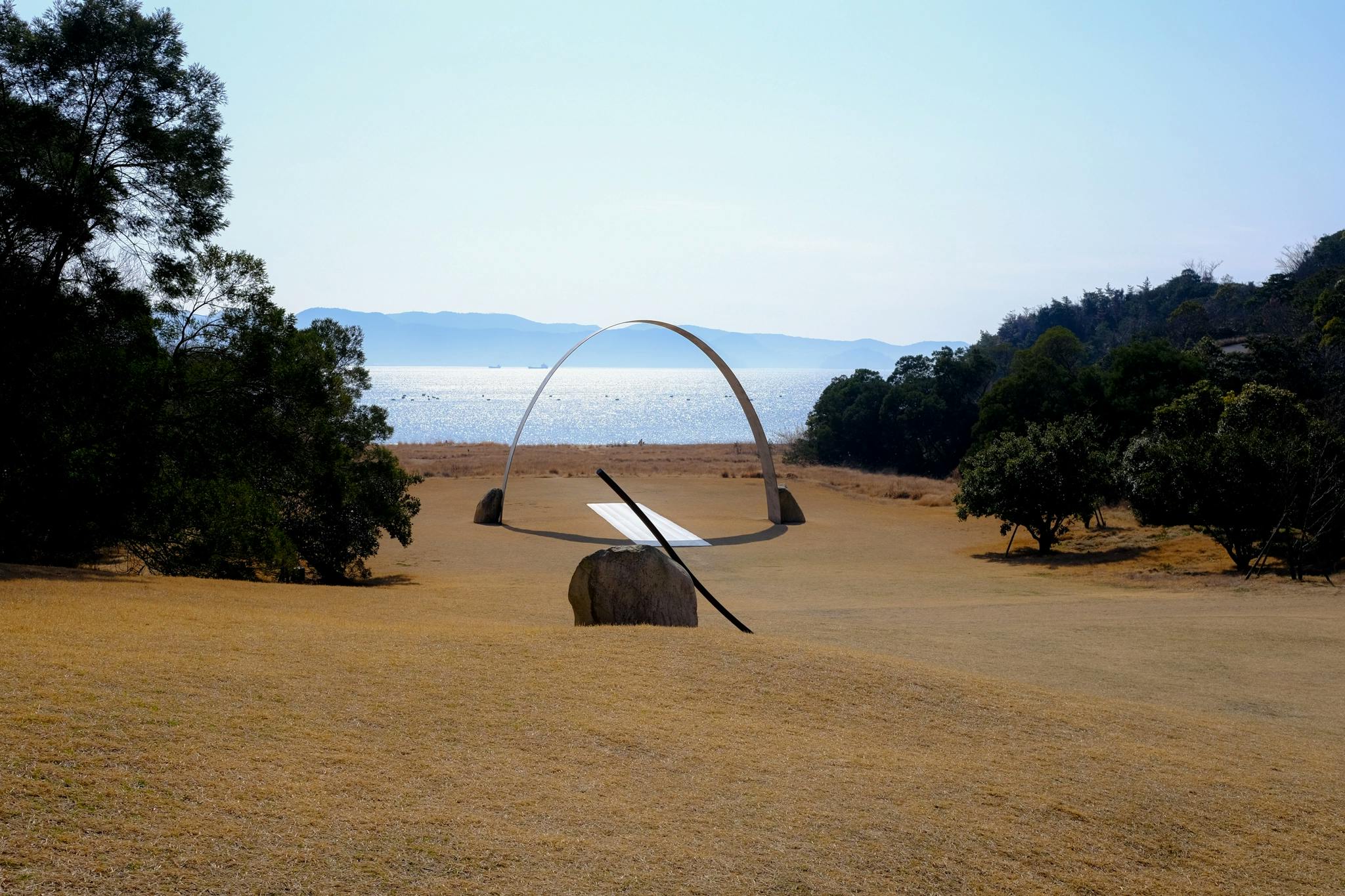 An outdoor sculpture by Lee Ufan on the lawn leading to the sea on Naoshima Island