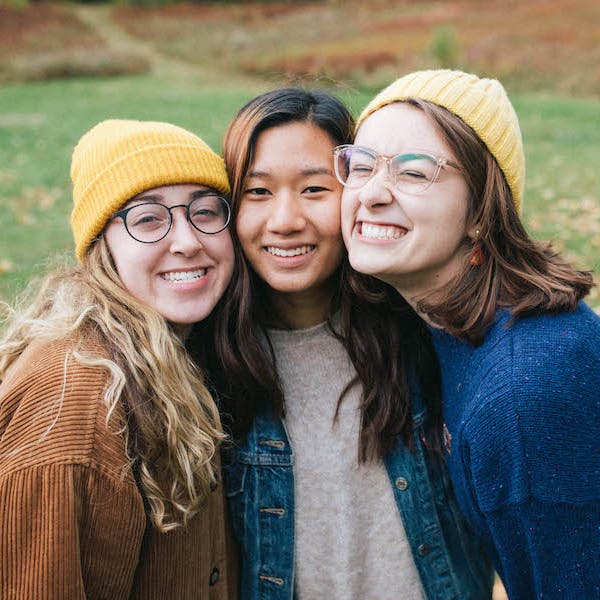 3 students smiling together at Scout's fall retreat