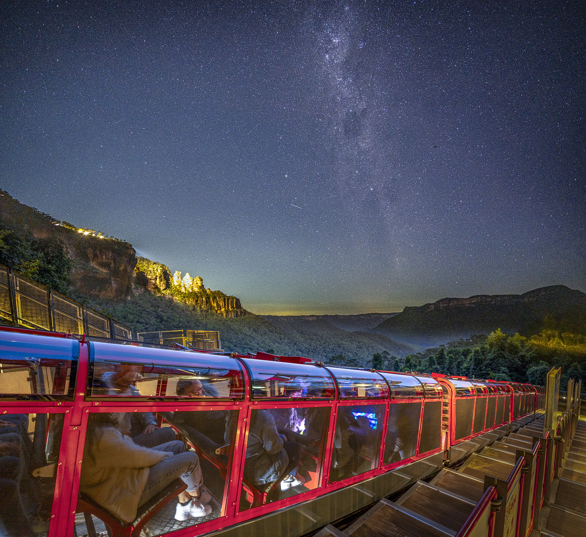 The Scenic Railway at night in front of the Three Sisters and a starry sky