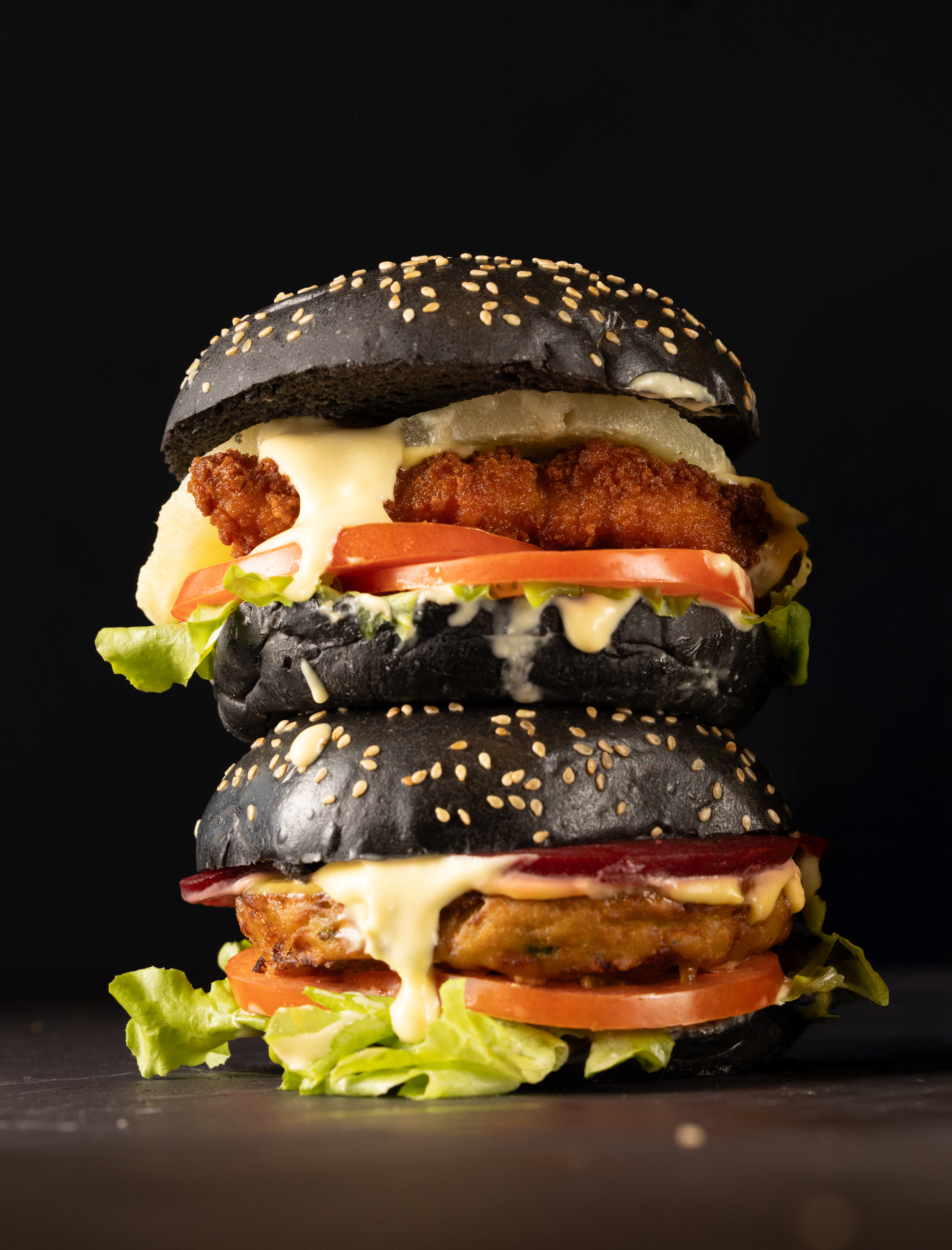 two juicy burgers stacked on top of each other