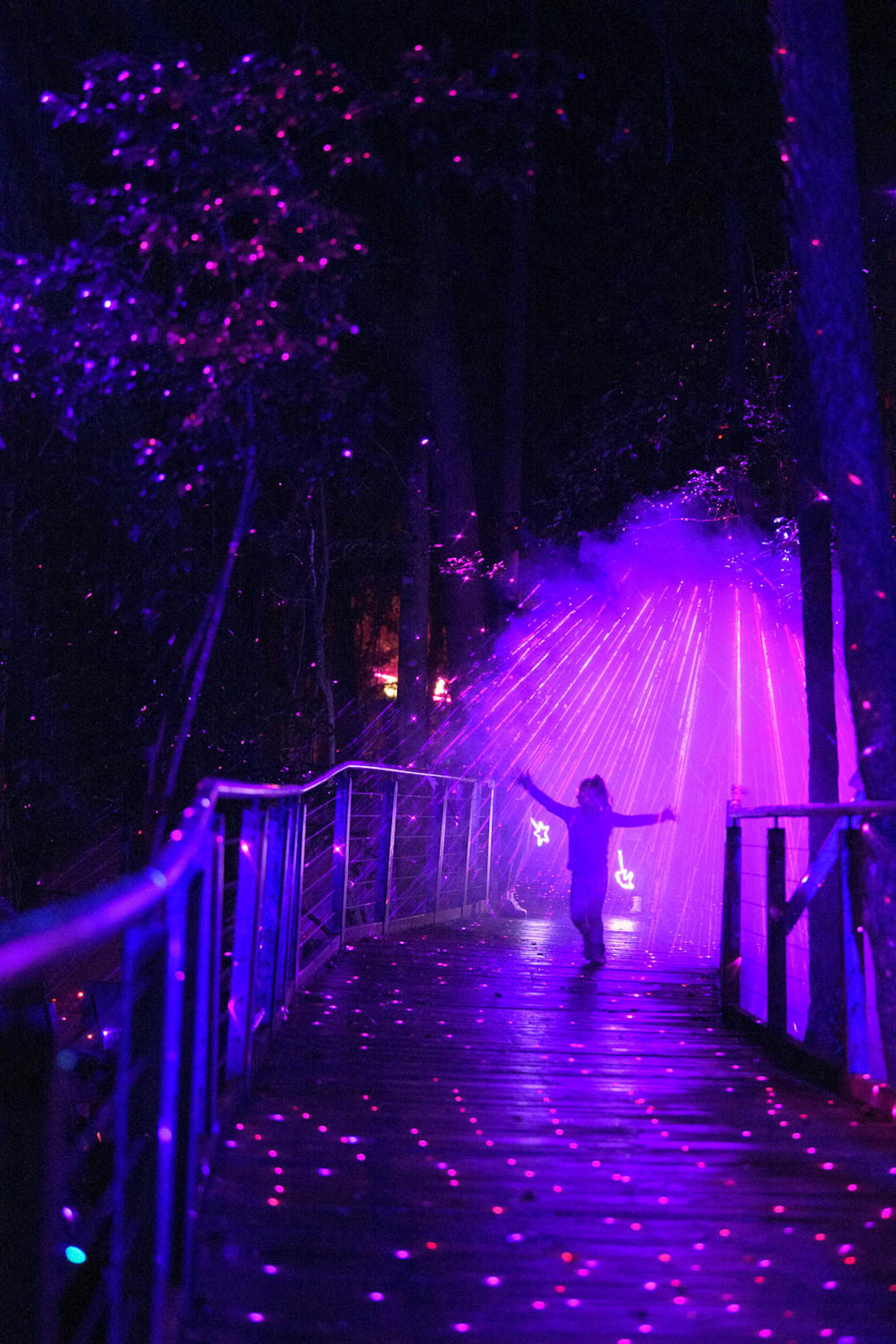 Girl on Scenic Walkway at night with laser lights