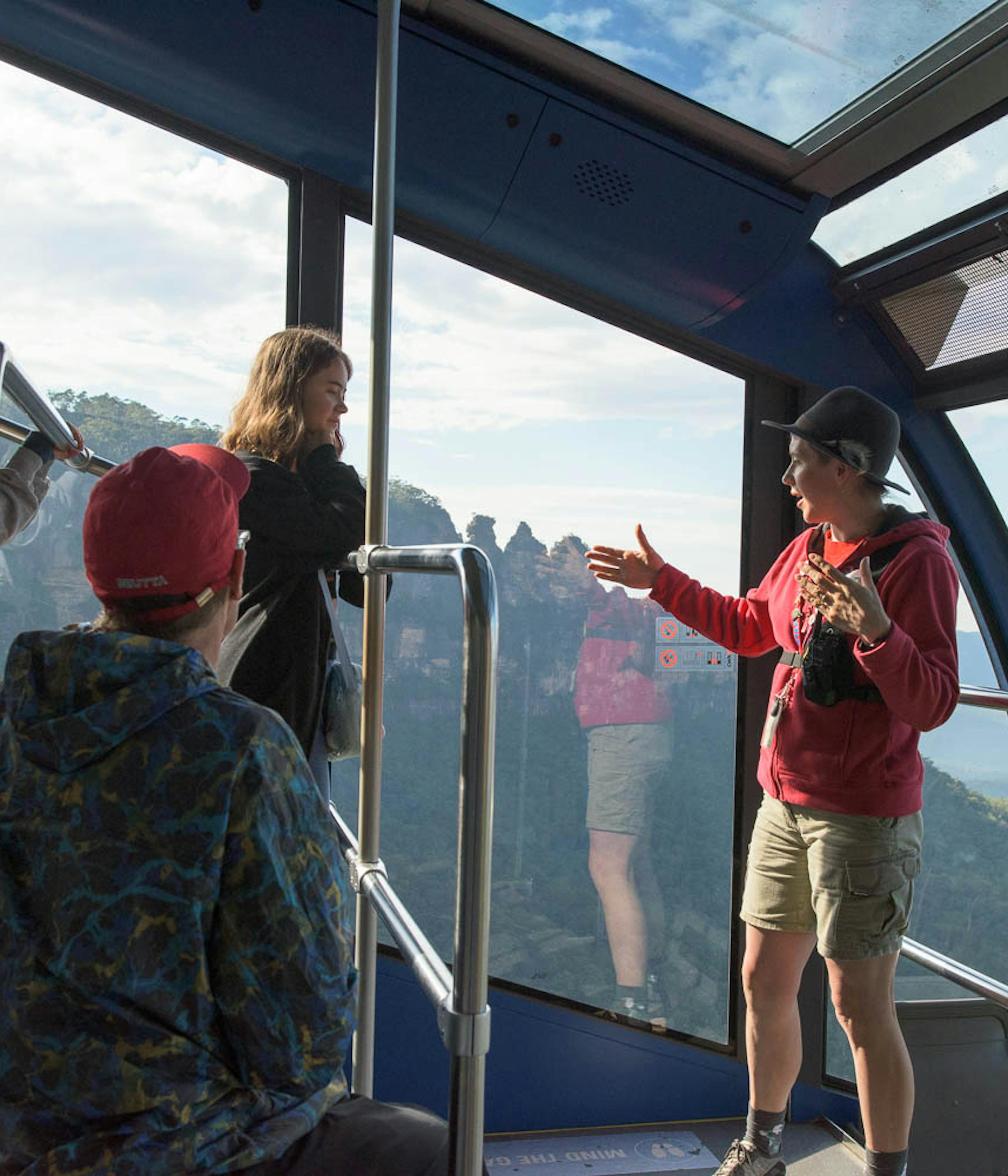 A guide is talking on the Scenic Cableway with a group of people.