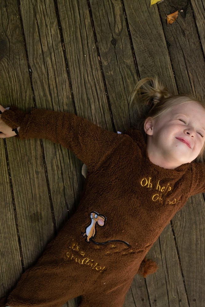 Girl in Gruffalo outfit lying down on Scenic Walkway boardwalk smiling