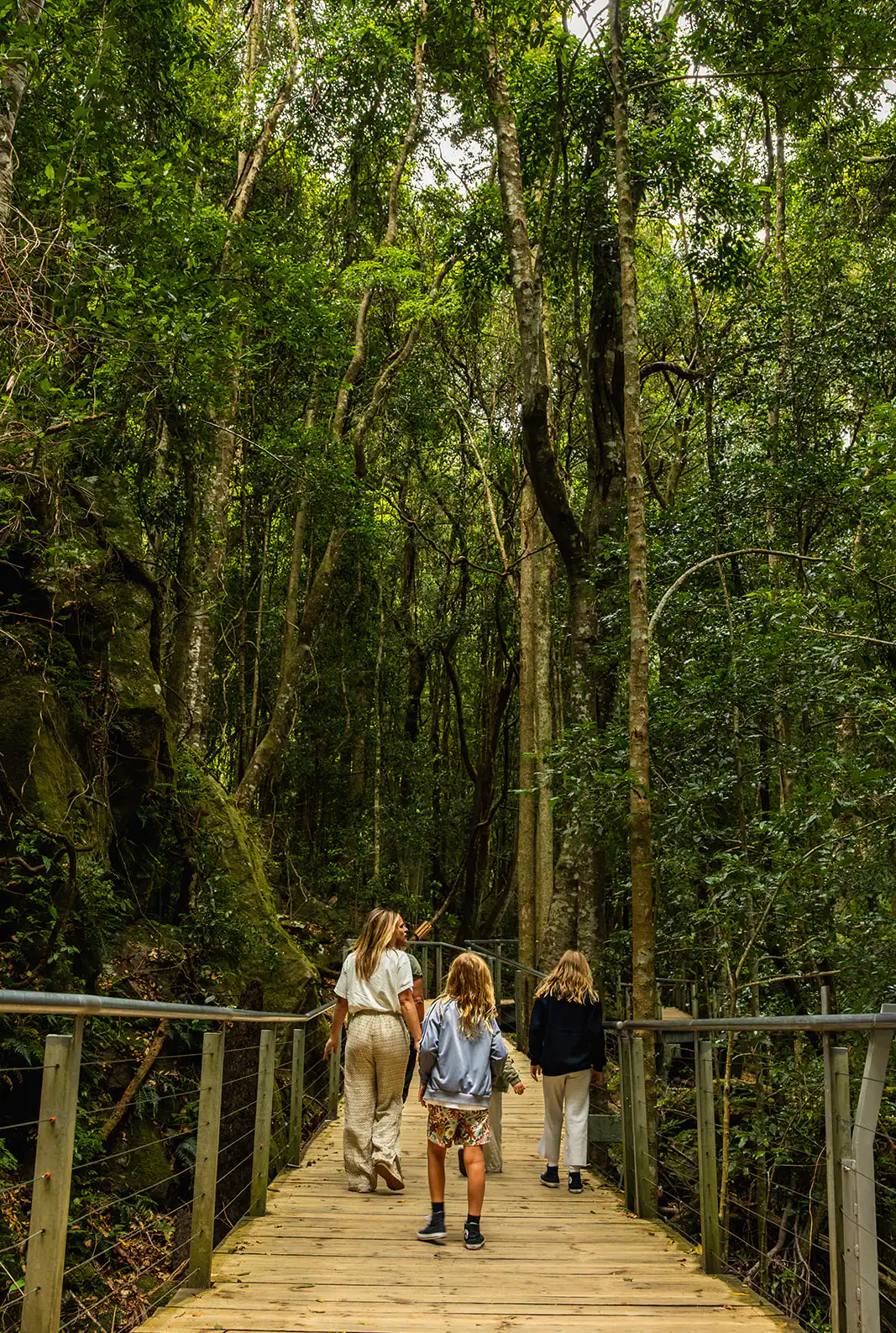 A family walks along the boardwalk of the Scenic Walkway