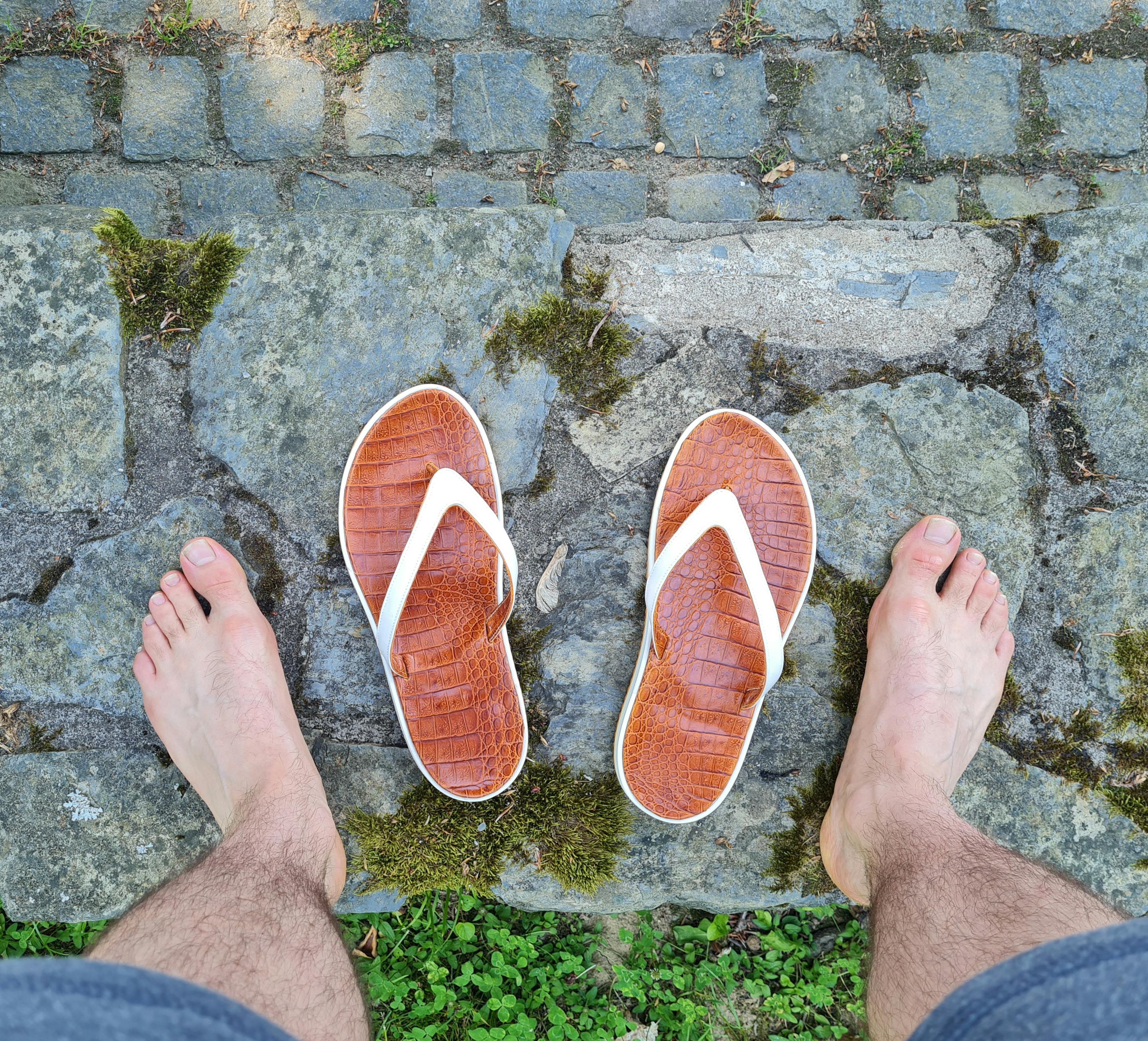 Die Sandale auf einer Mauer. Schuhmacherei Schmids Sandale nach Maß