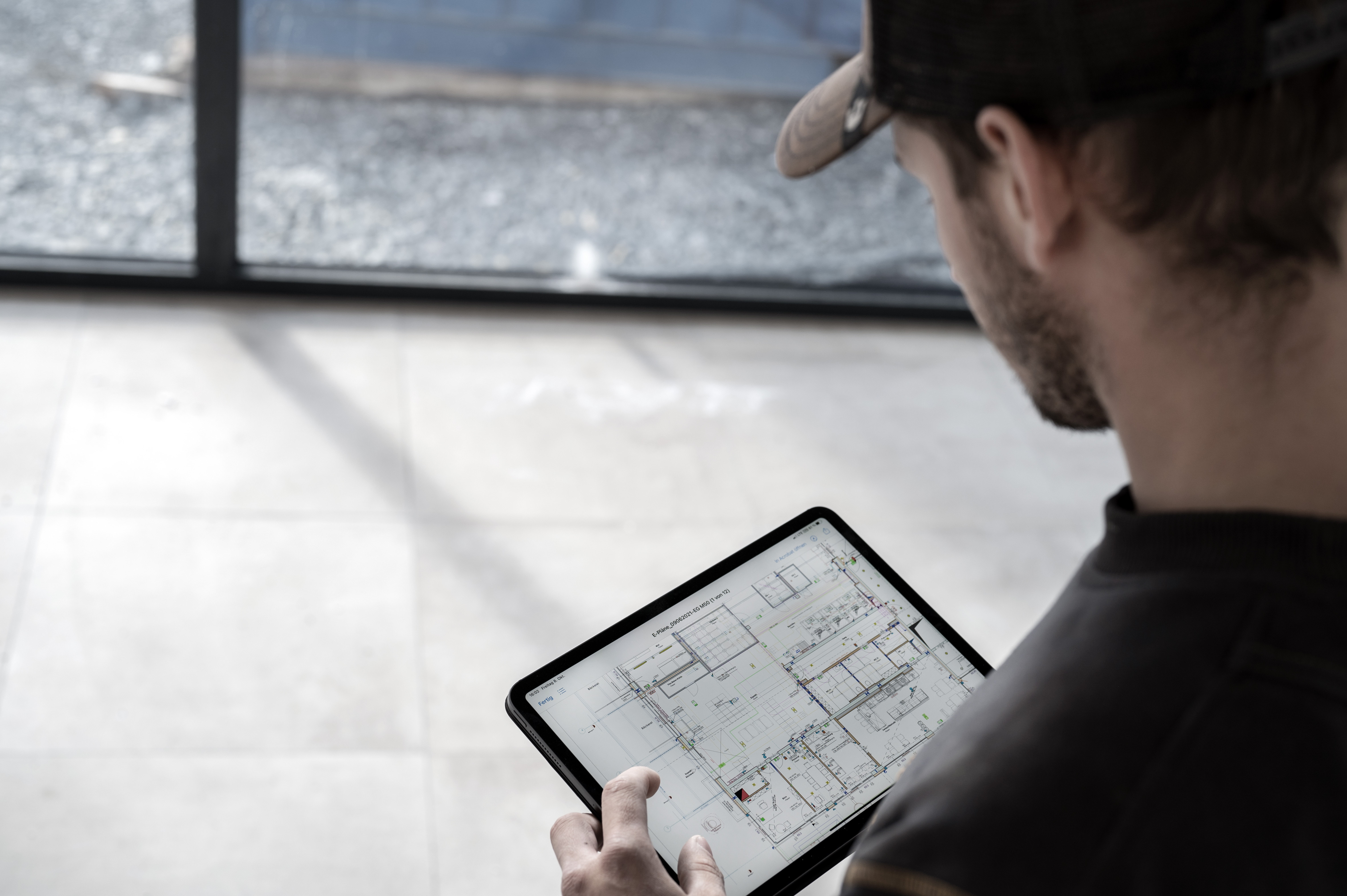 Mitarbeiter mit digitalem Plan auf einer Baustelle