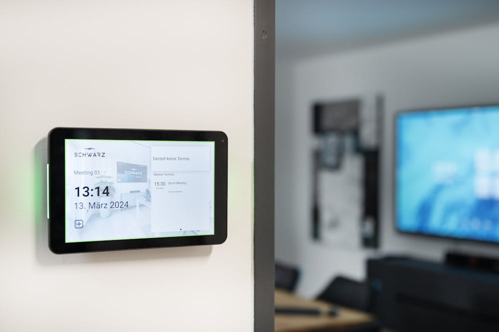 Room Manager Display mit Besprechungsraum im Hintergrund