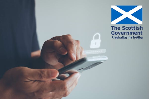 Person holding mobile phone with ScotGov logo in top-right corner
