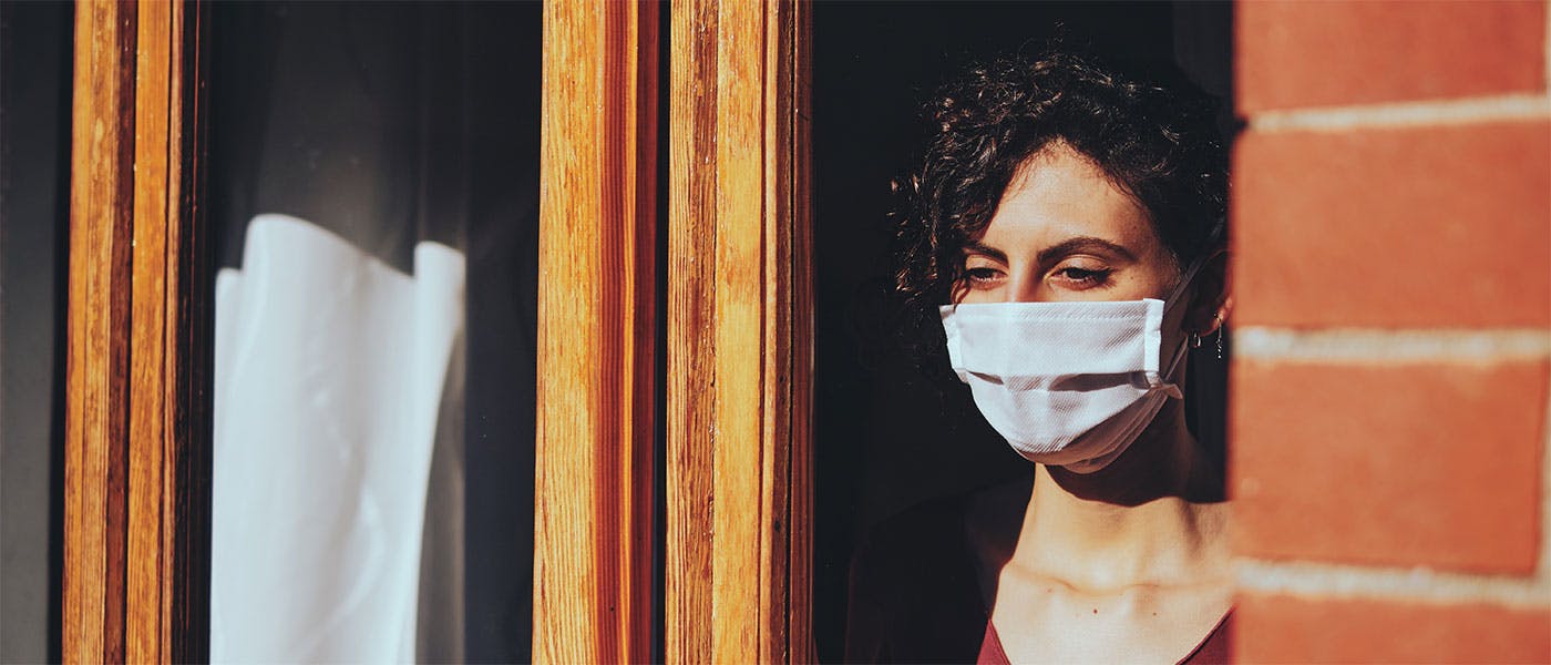 Woman wearing a face mask, sheltering during the COVID-19 pandemic