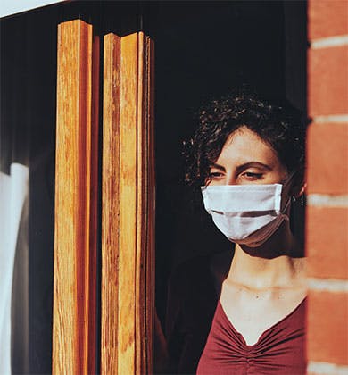 Woman wearing a face mask, sheltering during the COVID-19 pandemic