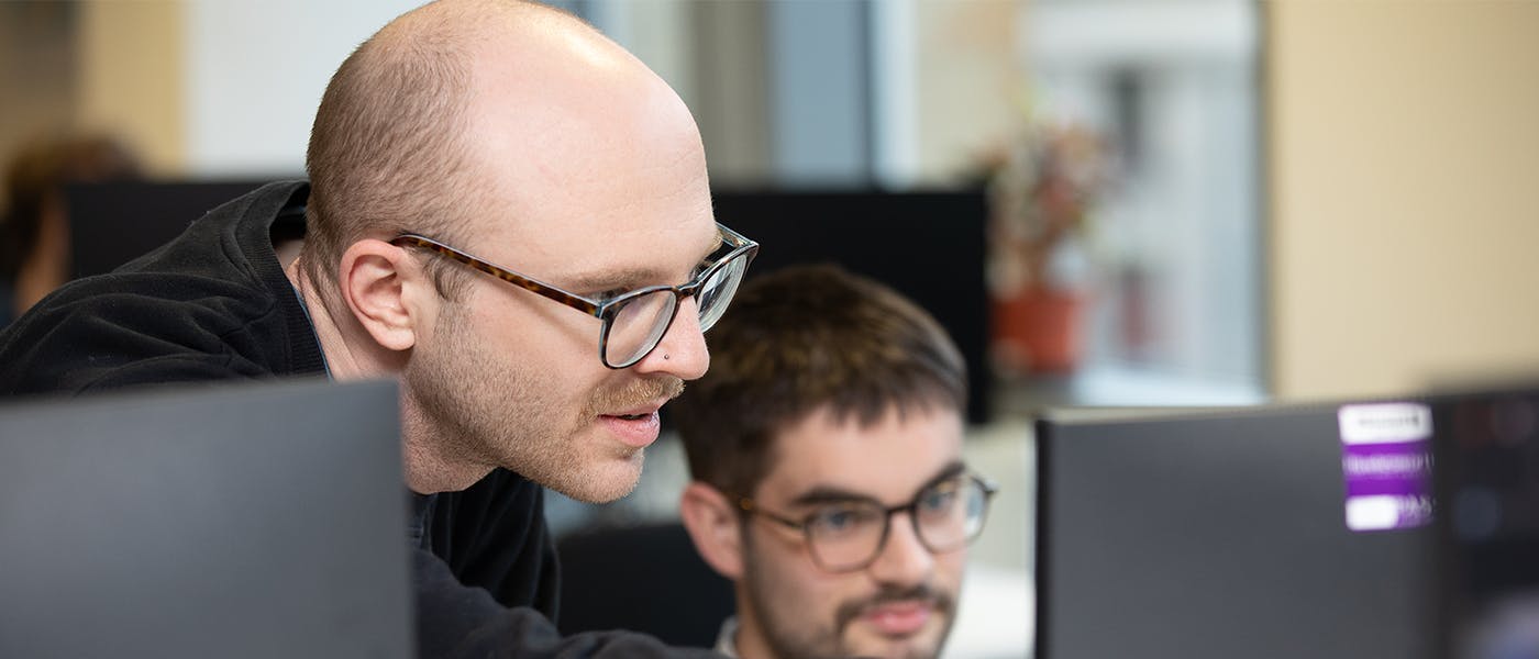 Two developers looking at computer monitor 