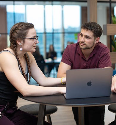 Three people in a discussion around a computer