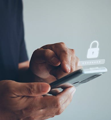 Hands holding a mobile phone and typing in a password