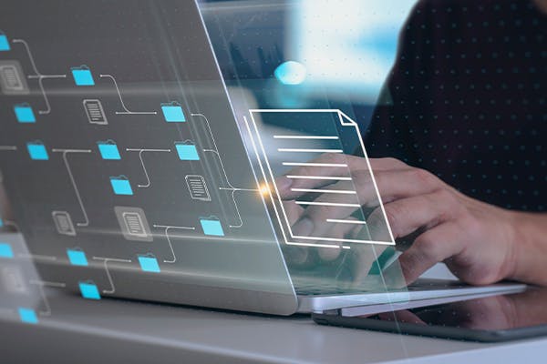 Person using laptop with a document outline