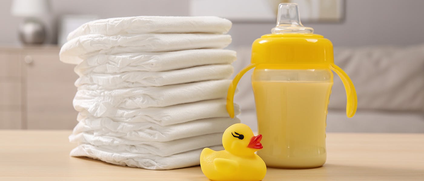 A table with towels, a rubber duck and a trainer cup