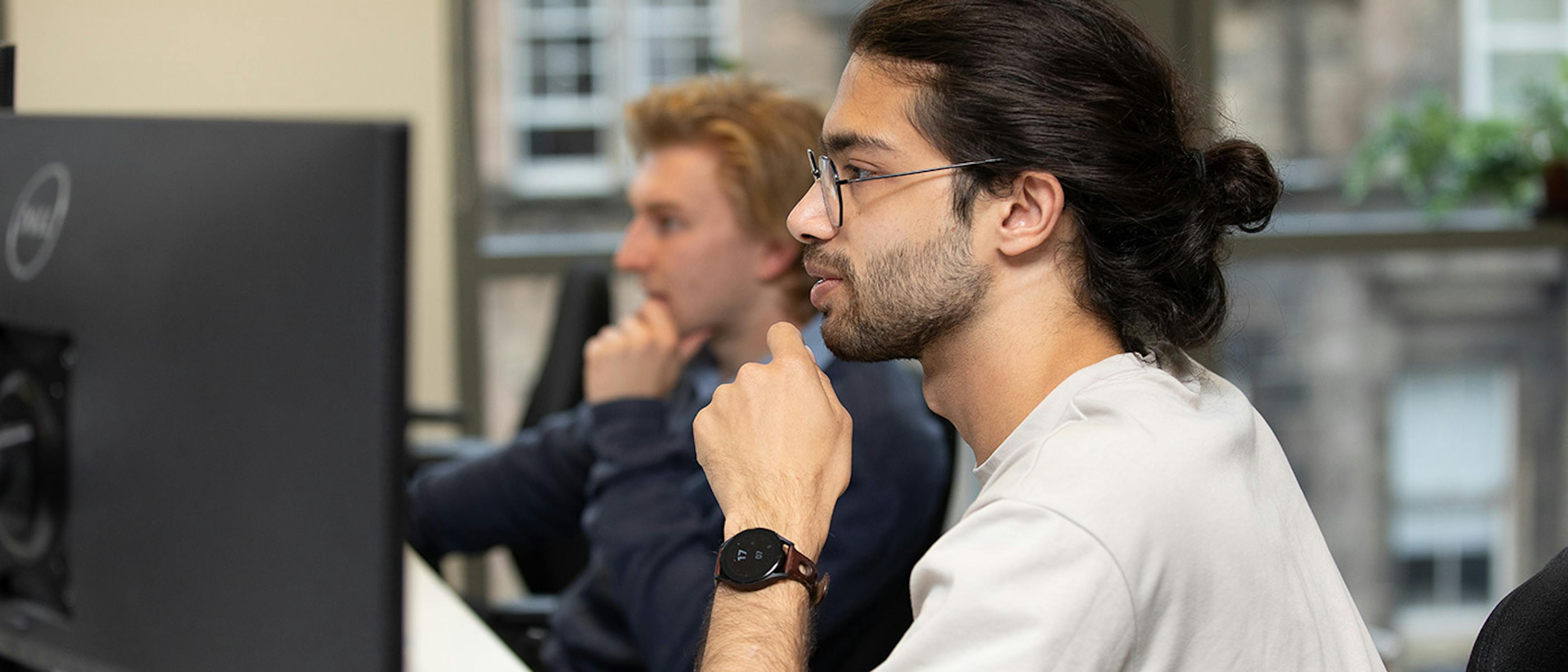 Two people in an office working at computers