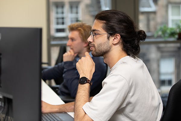 Two people in an office working at computers