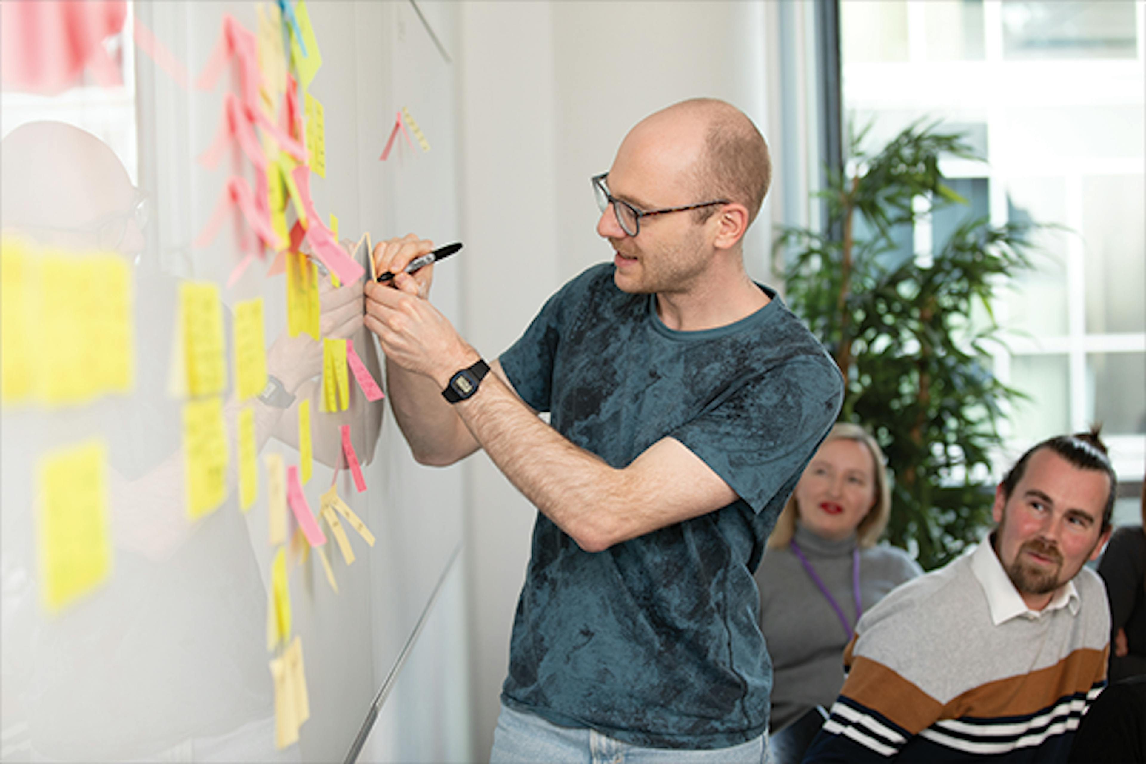 Person rights on sticky note during meeting