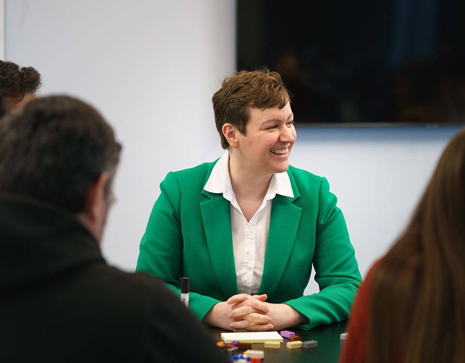 Woman smiling in a meeting with colleagues