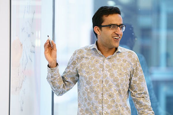 Man facilitating a group discussion at a whiteboard