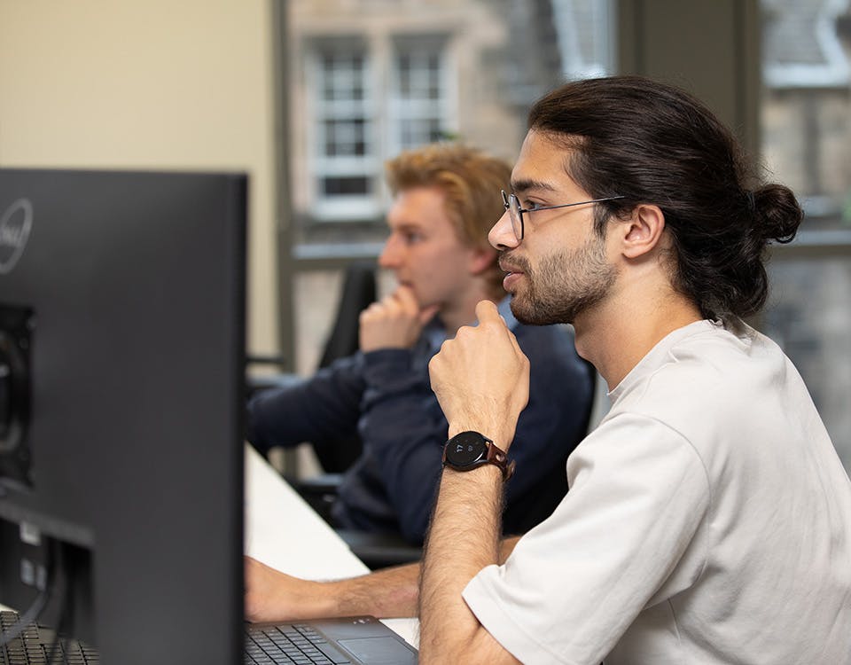 Two people in an office working at computers