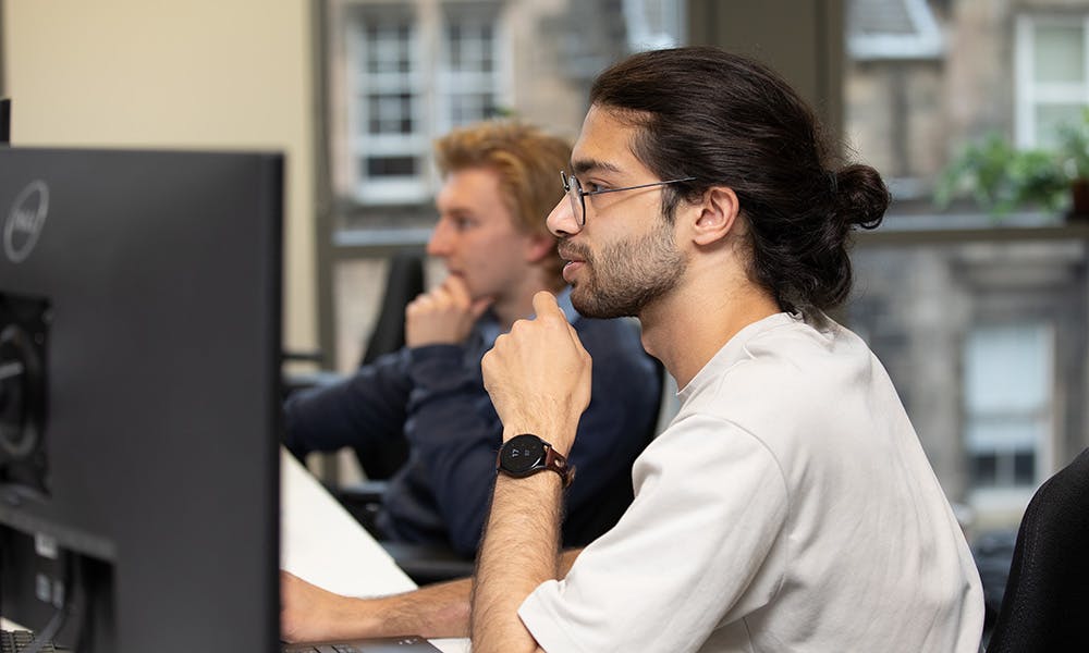 Two people in an office working at computers