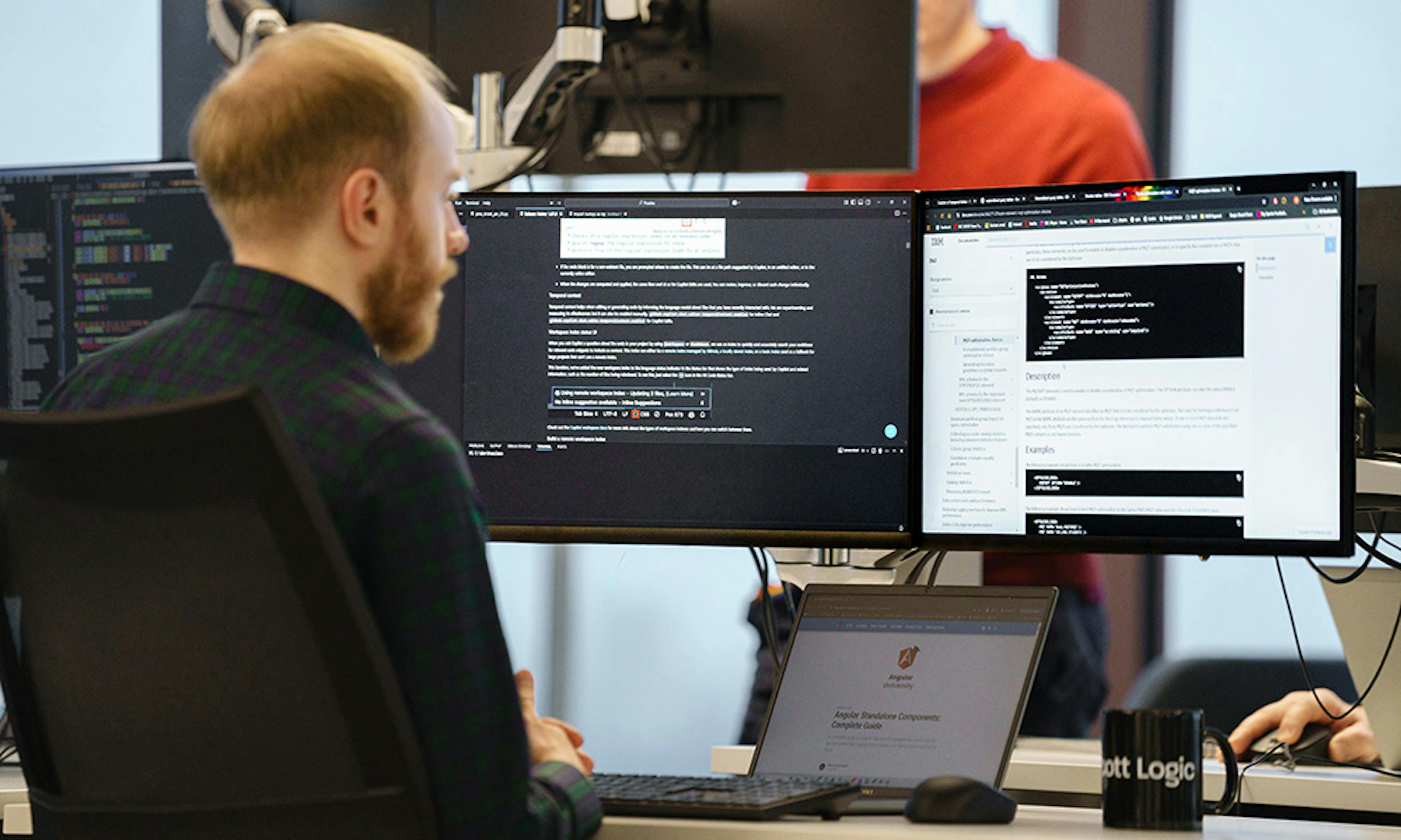 Developer working with three screens
