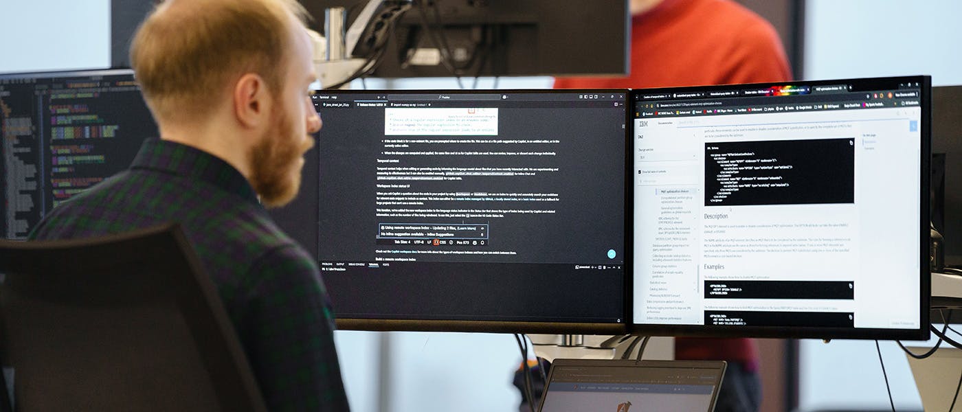 Developer working with three screens