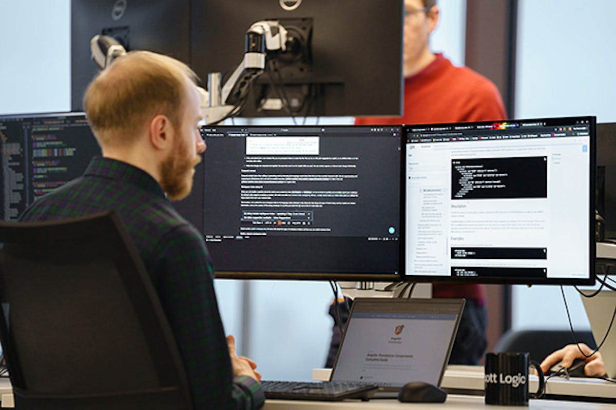 Developer working with three screens