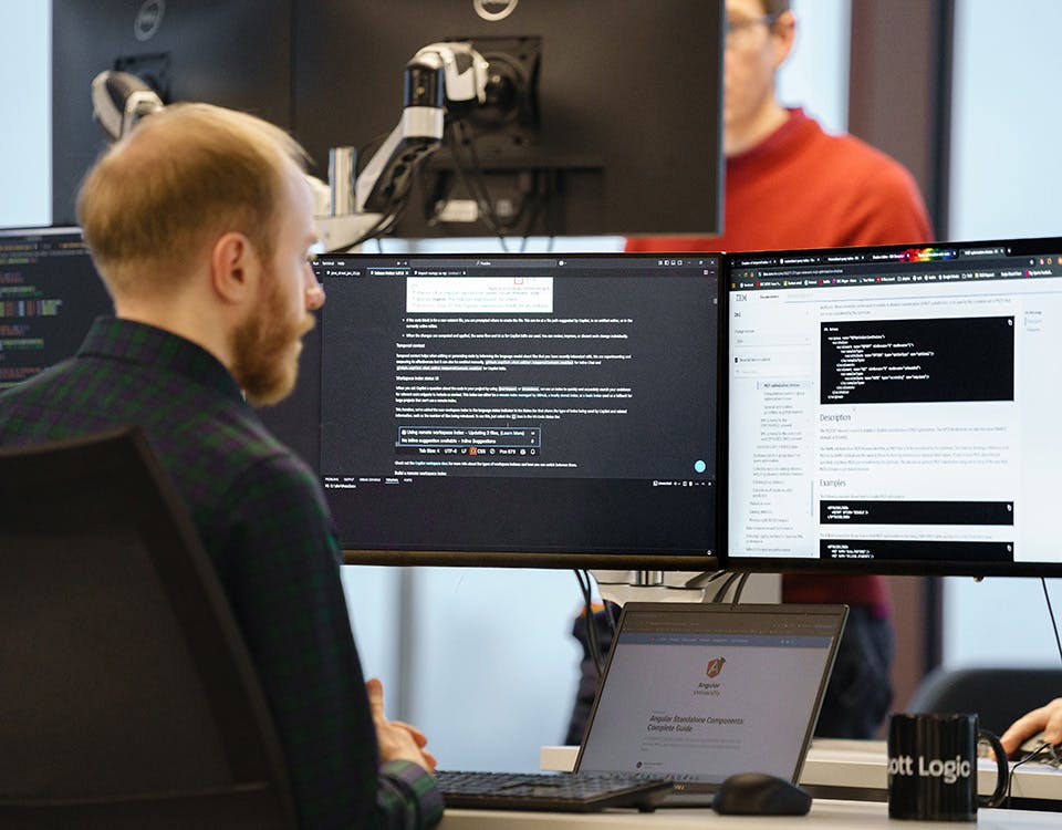 Developer working with three screens