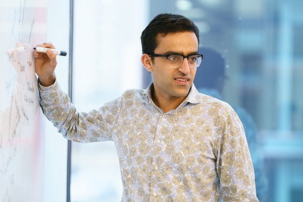 Man writing on a whiteboard in a meeting