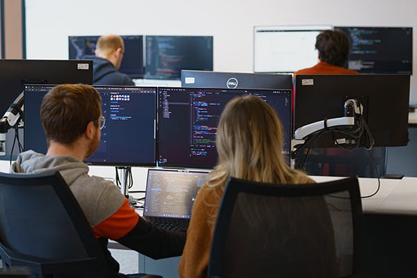 Two people pair programming in an office